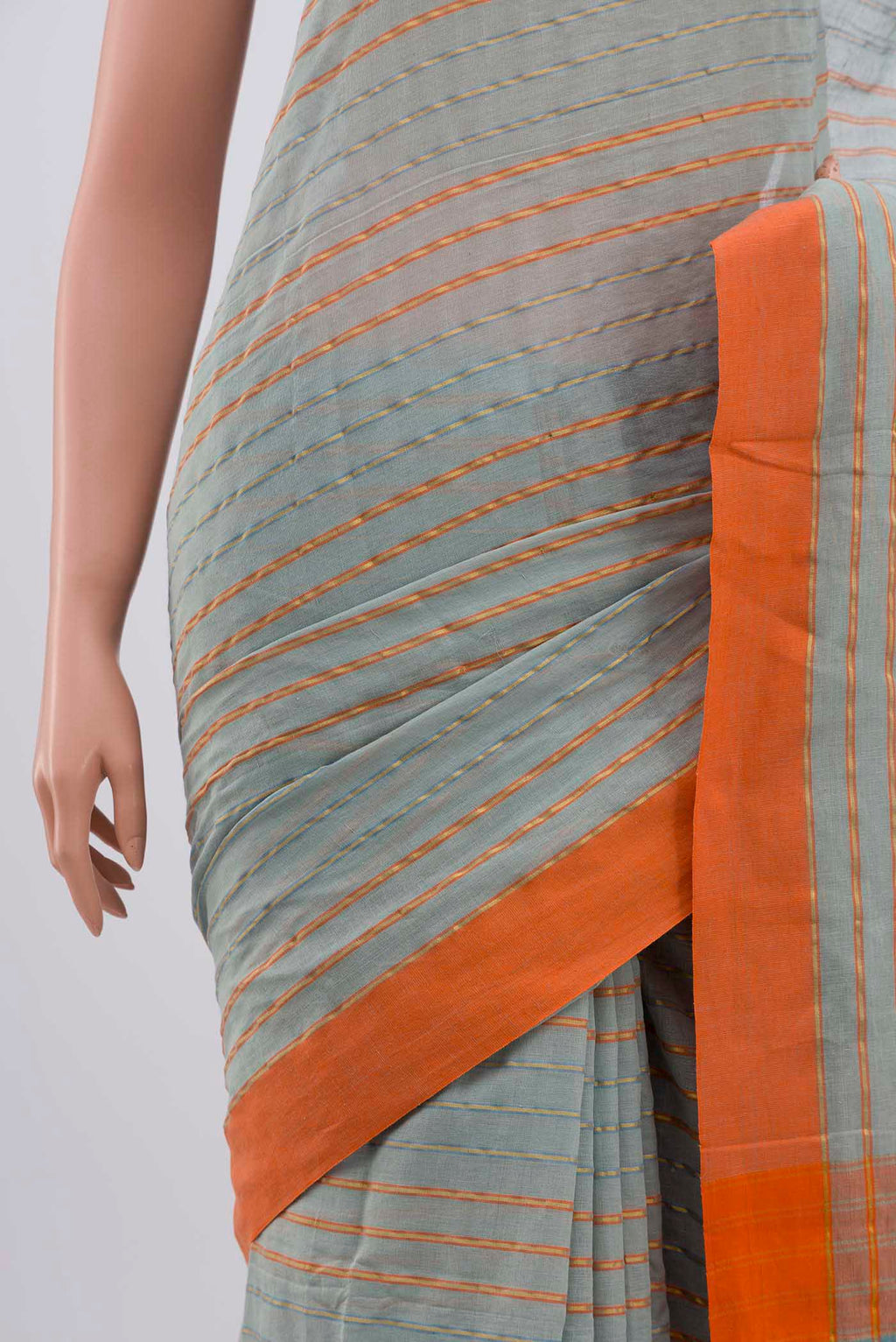 Border image of Mishri, a celebration of summer in Bengal cotton, is woven in fine 60-count cotton and drapes with natural comfort Soft stripes move in gentle linear patterns across the fabric, creating a lively yet balanced design The fine checks they form are a gentle reminder of crystal sugar, lending the saree its name Light, breathable, and effortlessly wearable for sunlit days