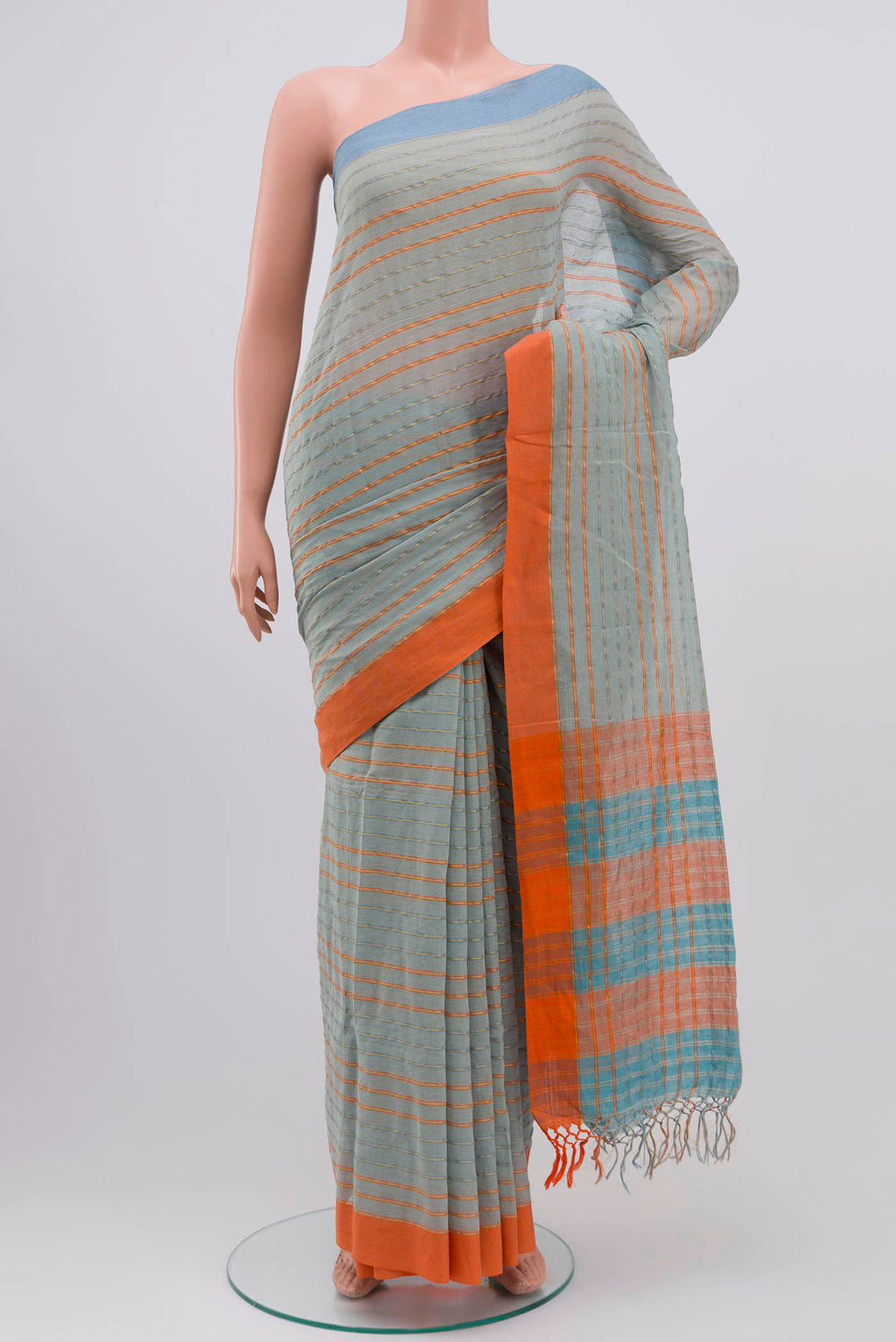 Mishri, a celebration of summer in Bengal cotton, is woven in fine 60-count cotton and drapes with natural comfort Soft stripes move in gentle linear patterns across the fabric, creating a lively yet balanced design The fine checks they form are a gentle reminder of crystal sugar, lending the saree its name Light, breathable, and effortlessly wearable for sunlit days displayed on a mannequin