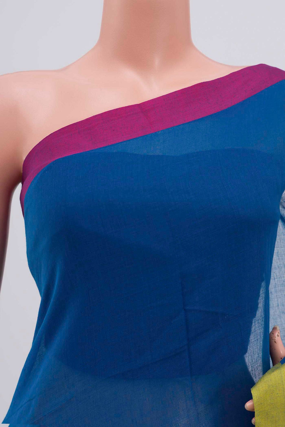 Close up of Chhaya, our Bengal cotton saree, draws inspiration from the clean, modern lines of Piet Mondrian A contrasting band forms the top border, creating a striking visual highlight across the body, while minimal stripes along the base and pallu introduce structure and balance Bold colour blocks reinterpret Chhaya, meaning shadow in Hindi, and the solid pallu completes the look with contemporary ease displaying folds