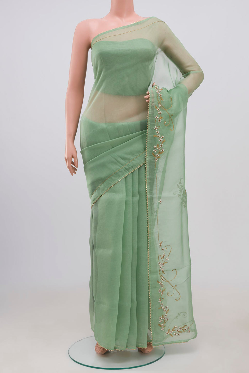 Green Organza Silk Saree with Embroidery on the body and Embroidery Border displayed on a mannequin