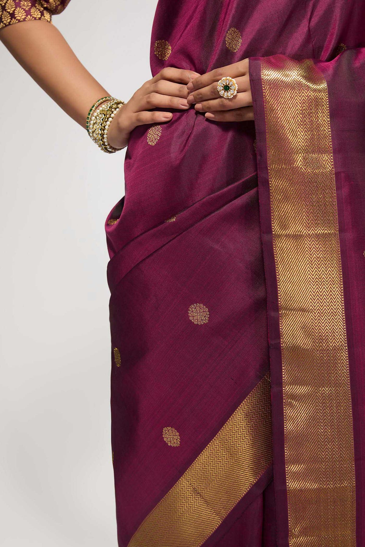 Close up of Pure Silk Pure Zari Maroon Kanchipuram Saree with Zari Butta on the body and Zari Border displaying folds