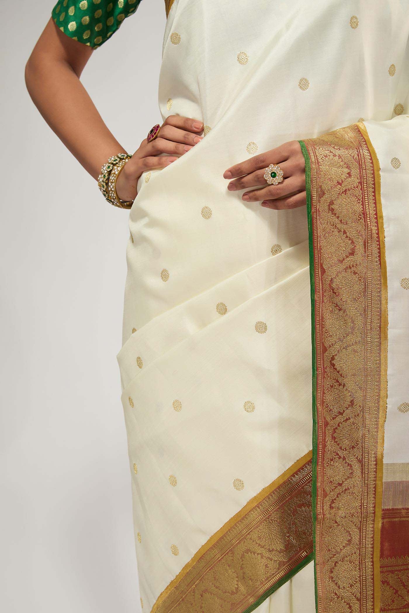 Close up of Pure Silk Pure Zari Off White Kanchipuram Saree with Zari Butta on the body and Zari Border displaying folds