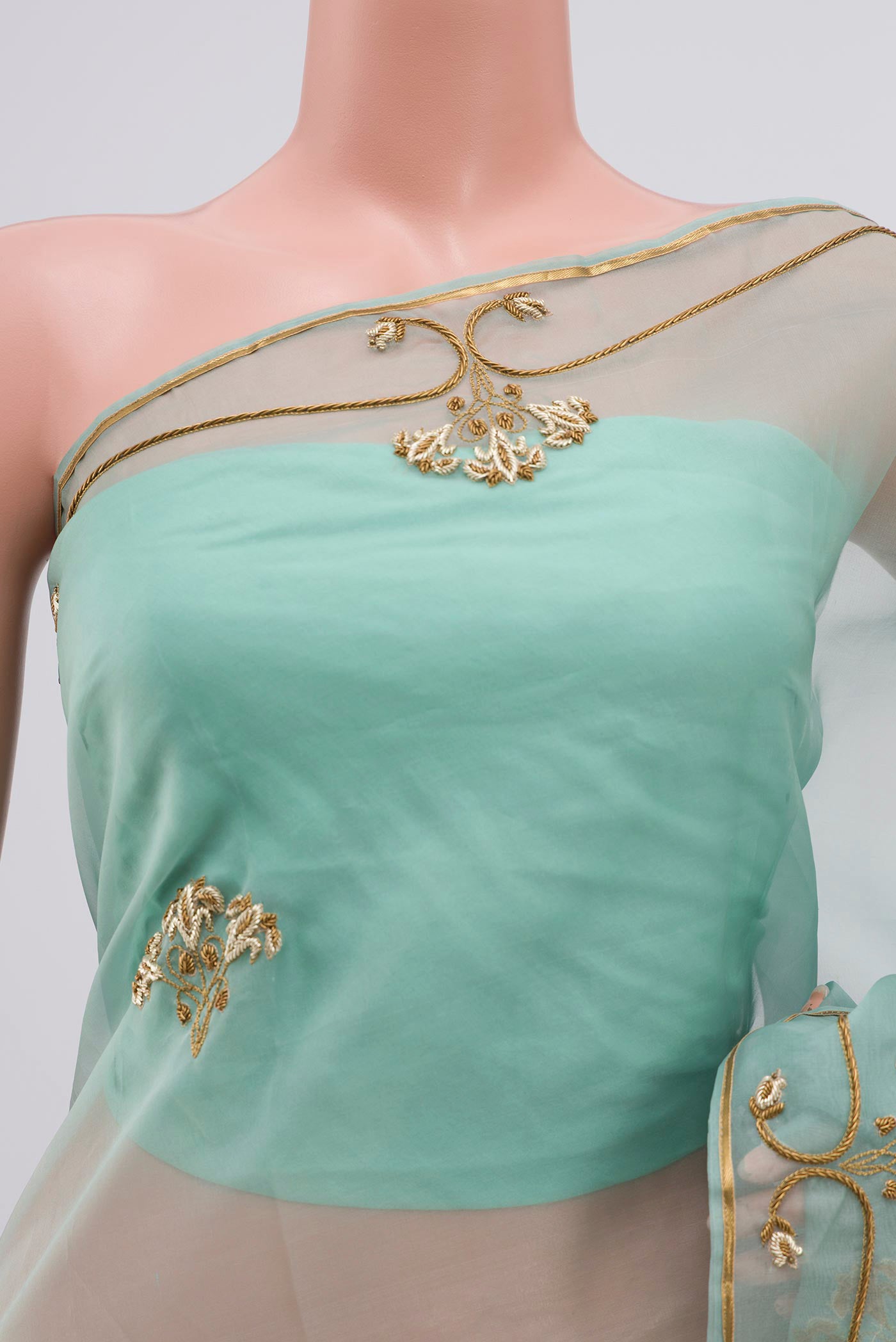 Close up of Green Organza Silk Saree with Embroidery on the body and Embroidery Border displaying folds