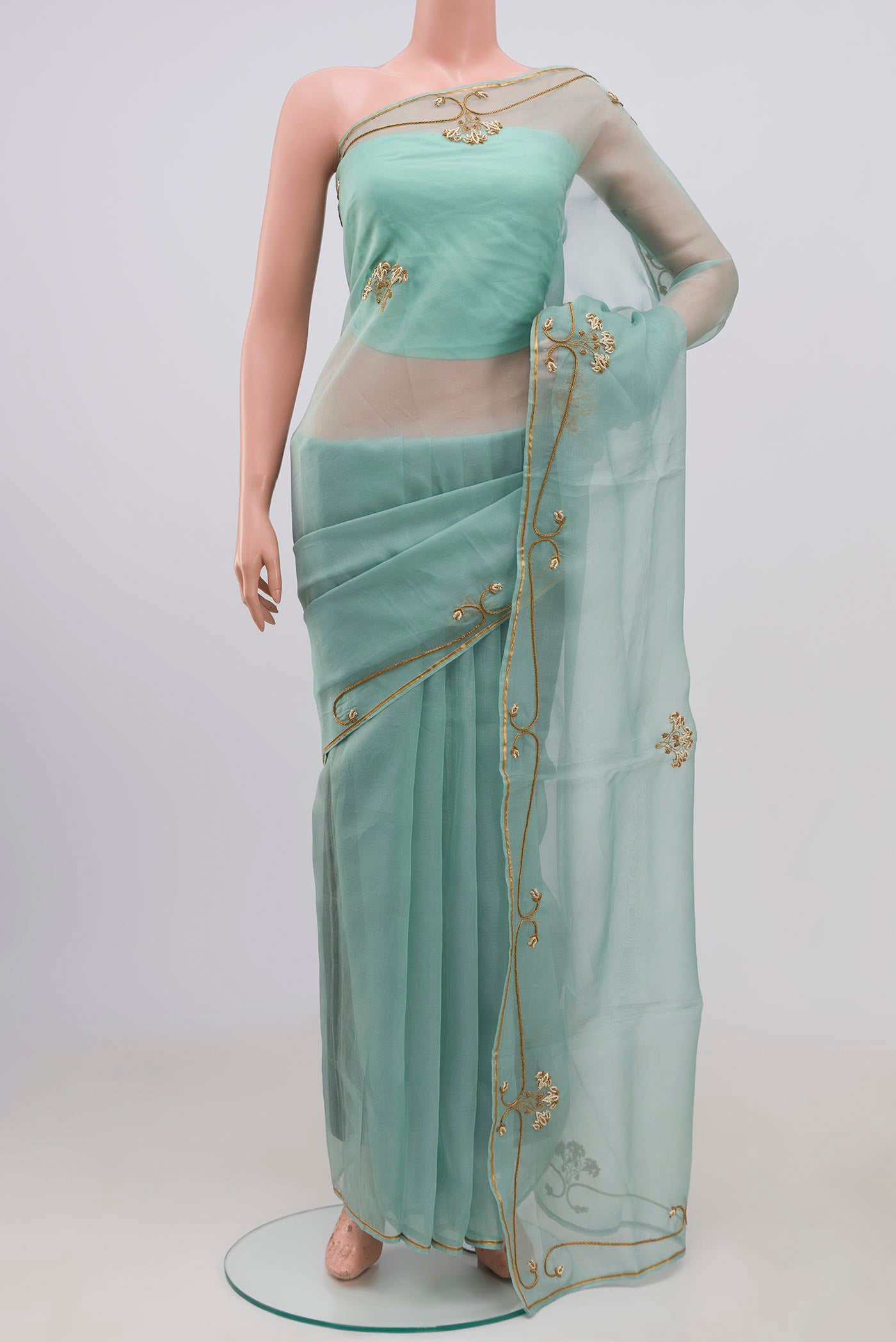 Green Organza Silk Saree with Embroidery on the body and Embroidery Border displayed on a mannequin