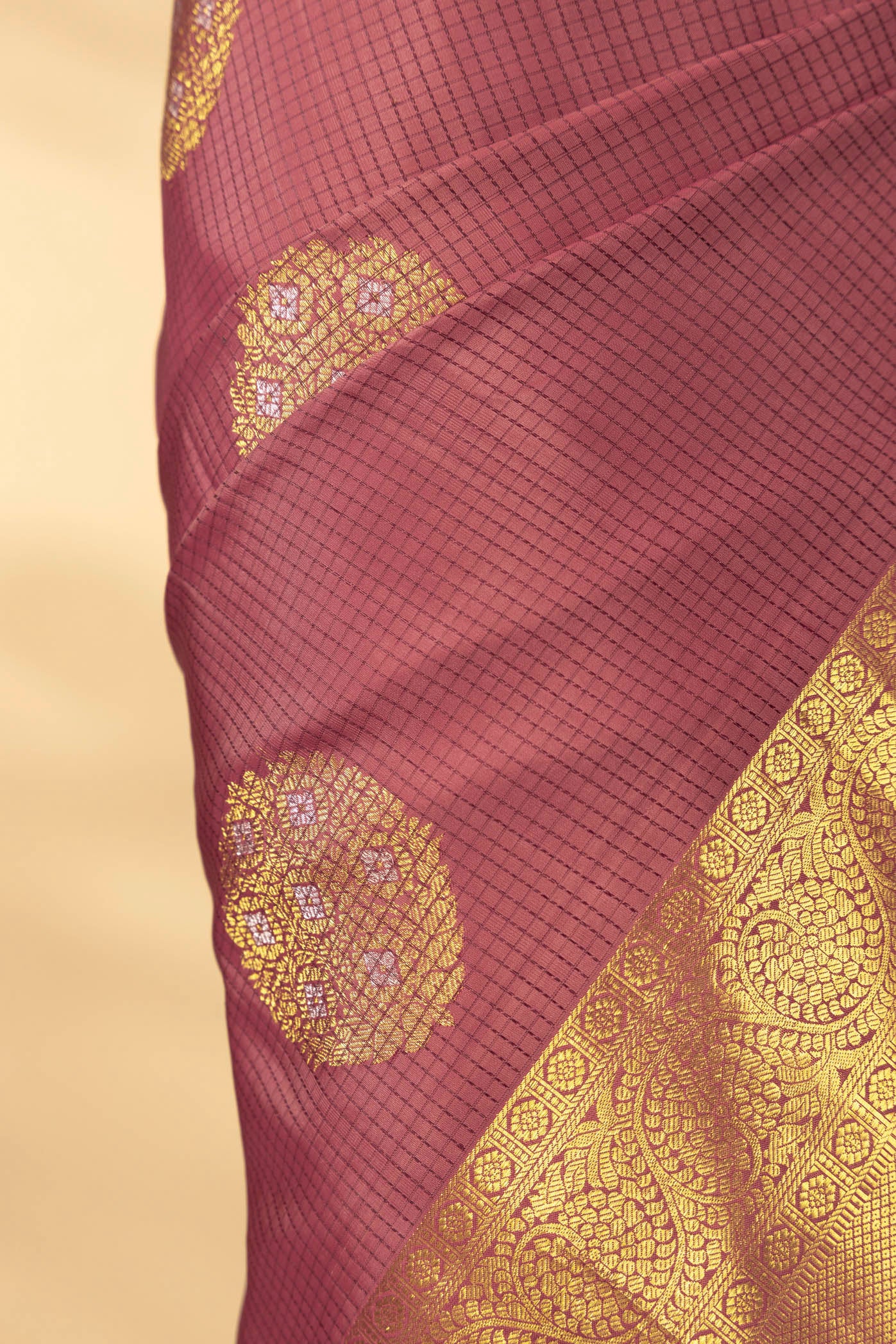 Close up of Coral Kanchipuram Silk Saree with Checked design on the body and Zari Border displaying folds