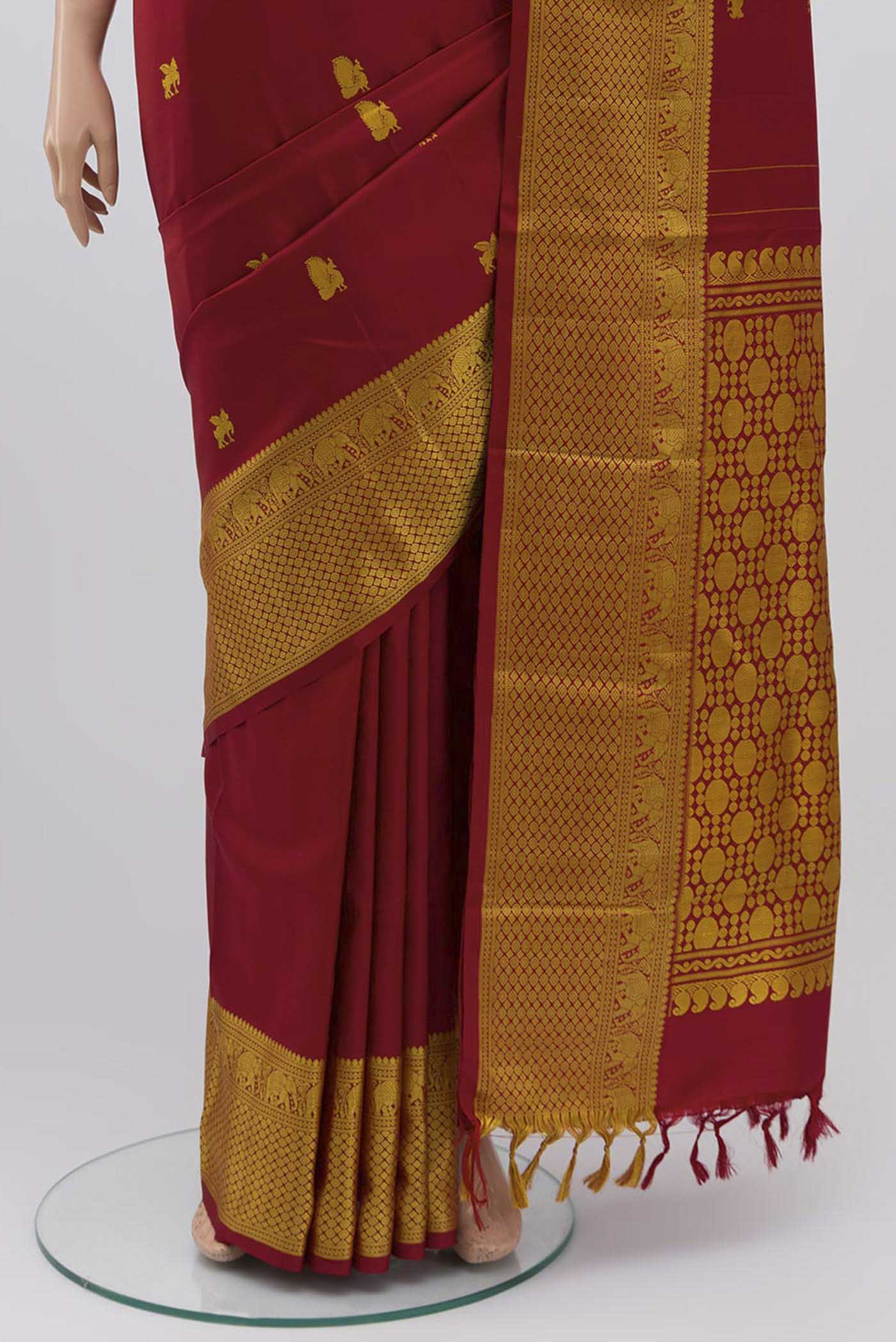 Pleats and pallu of Maroon Kanchipuram Silk Saree with Thread Butta on the body and Thread Border
