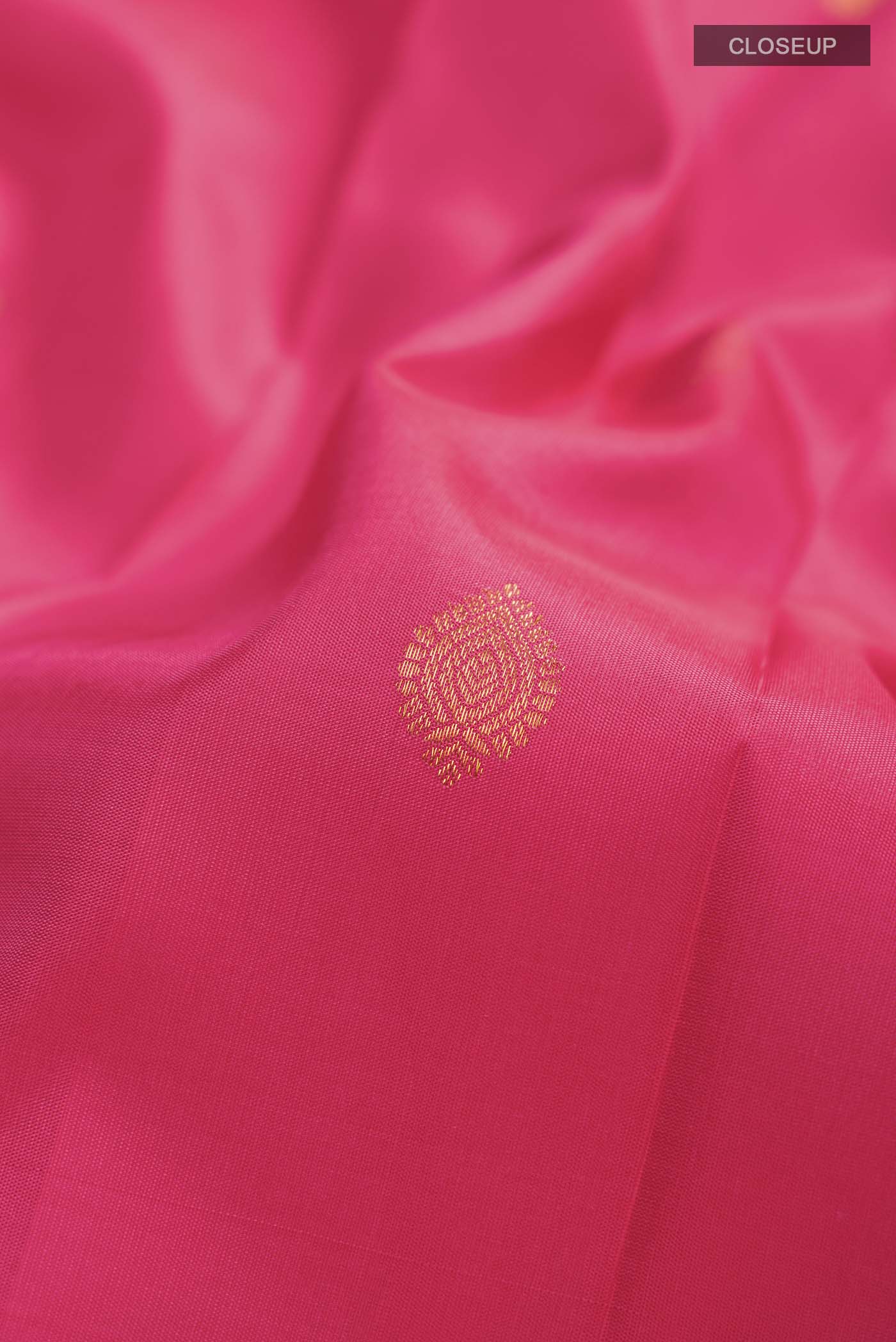 Close up of Pink Kanchipuram Silk Saree with Zari Butta on the body and Zari Border displaying folds