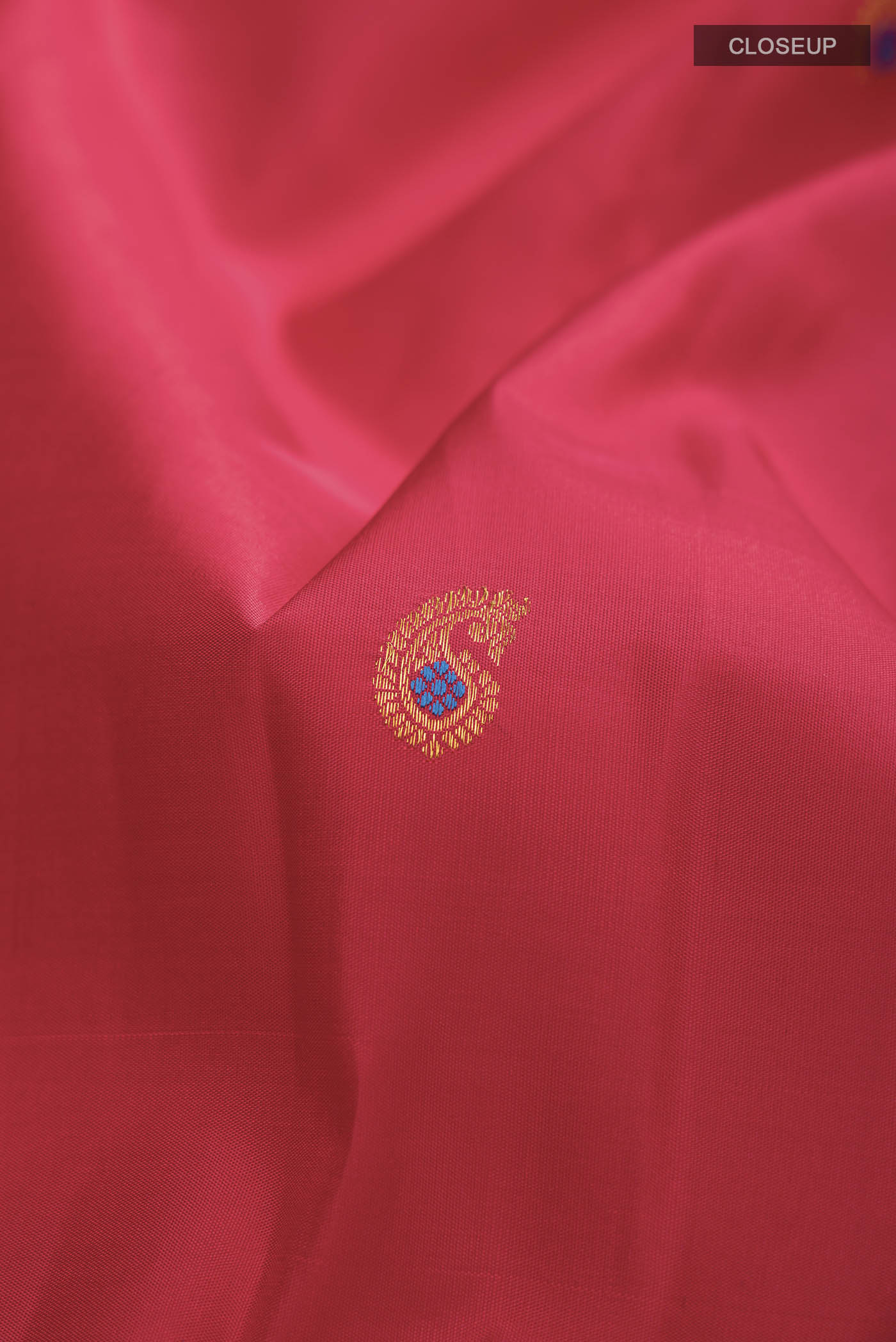 Close up of Red Kanchipuram Silk Saree with Zari Butta on the body and Plain Border displaying folds