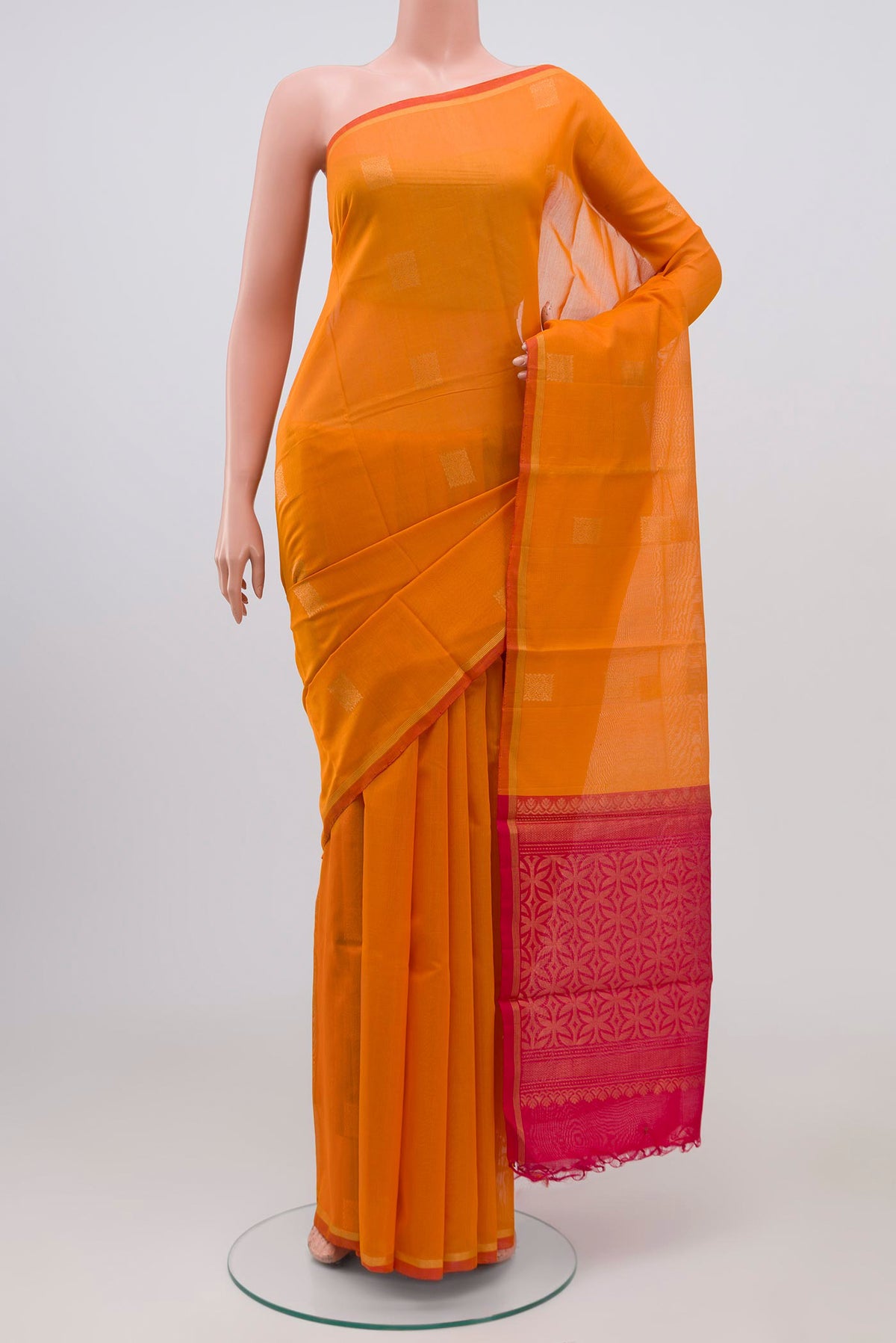 Orange Coimbatore Silk Cotton Saree with Zari Butta on the body and Zari Border.  displayed on a mannequin