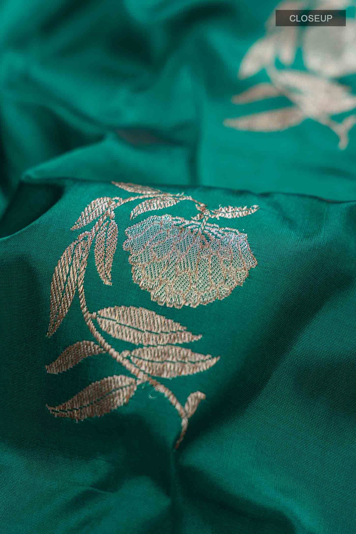 Close up of Teal Banarasi Katan Silk Saree with Zari Butta on the body and Satin Border displaying folds