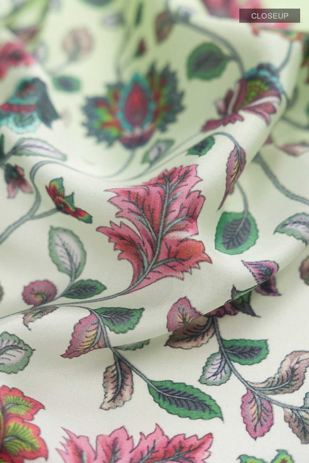 Close up of Green Mysore Crepe Saree with Floral Print on the body and Zari Border displaying folds