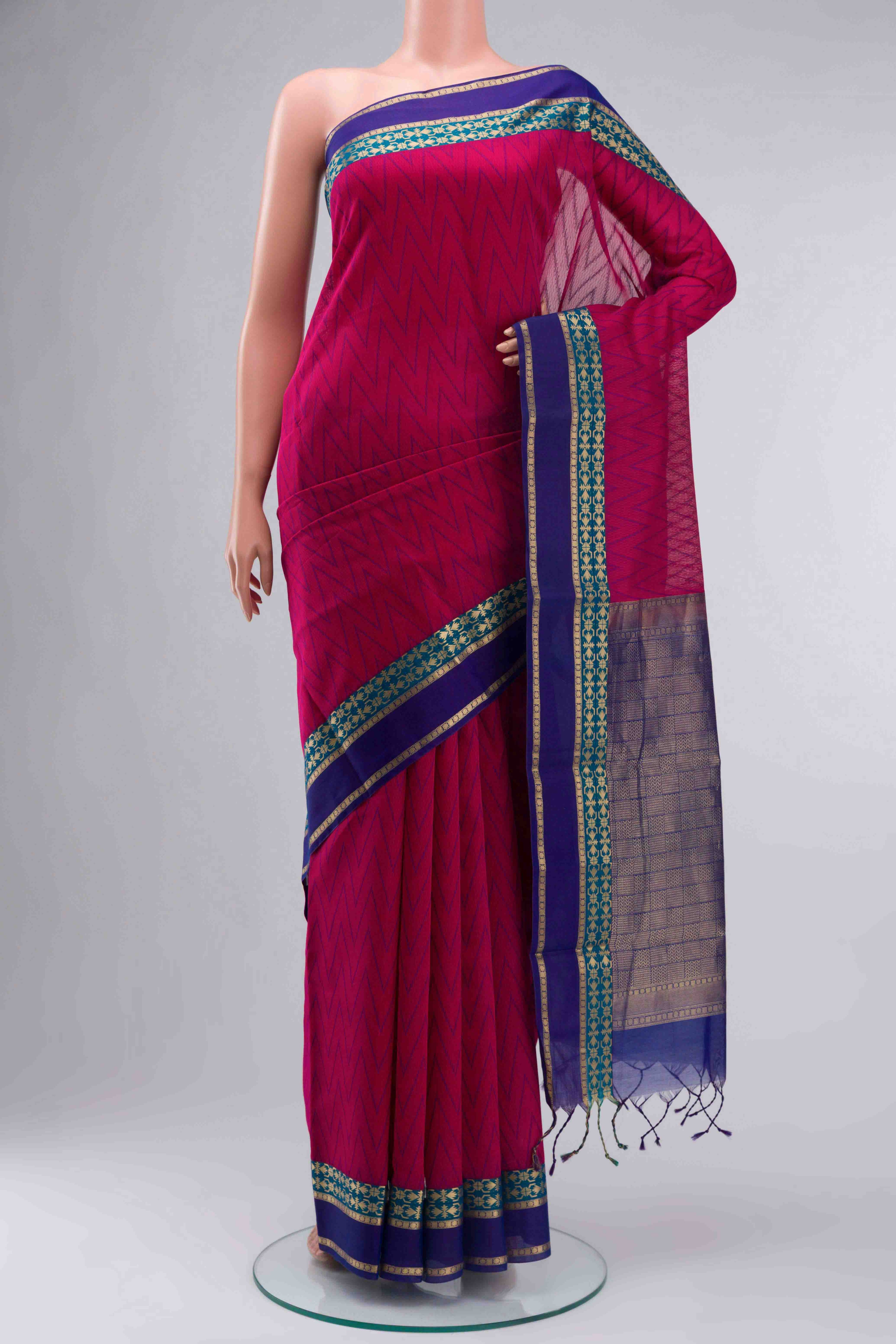 Pink Silk Cotton SareeZig Zag design on the body and Zari Border displayed on a mannequin
