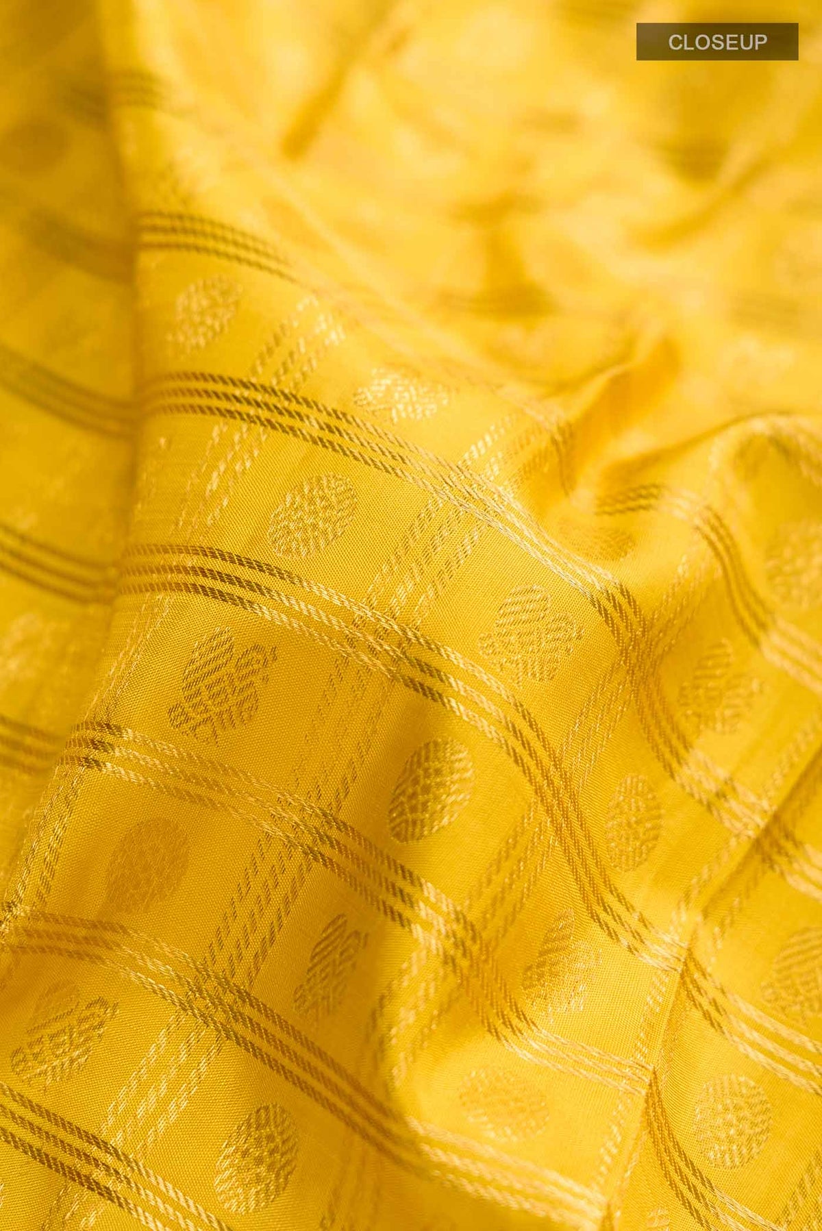 Close up of Yellow Kanchipuram Silk Saree with Zari Brocade on the body and Zari Border displaying folds