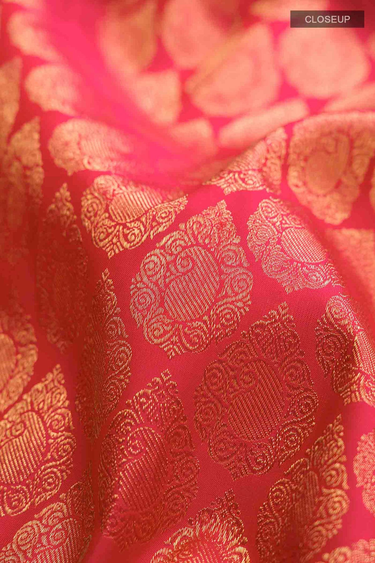 Close up of Pure Silk Pure Zari Red with Pink Color Kanchipuram Saree with Zari Brocade on the body and Zari Border displaying folds