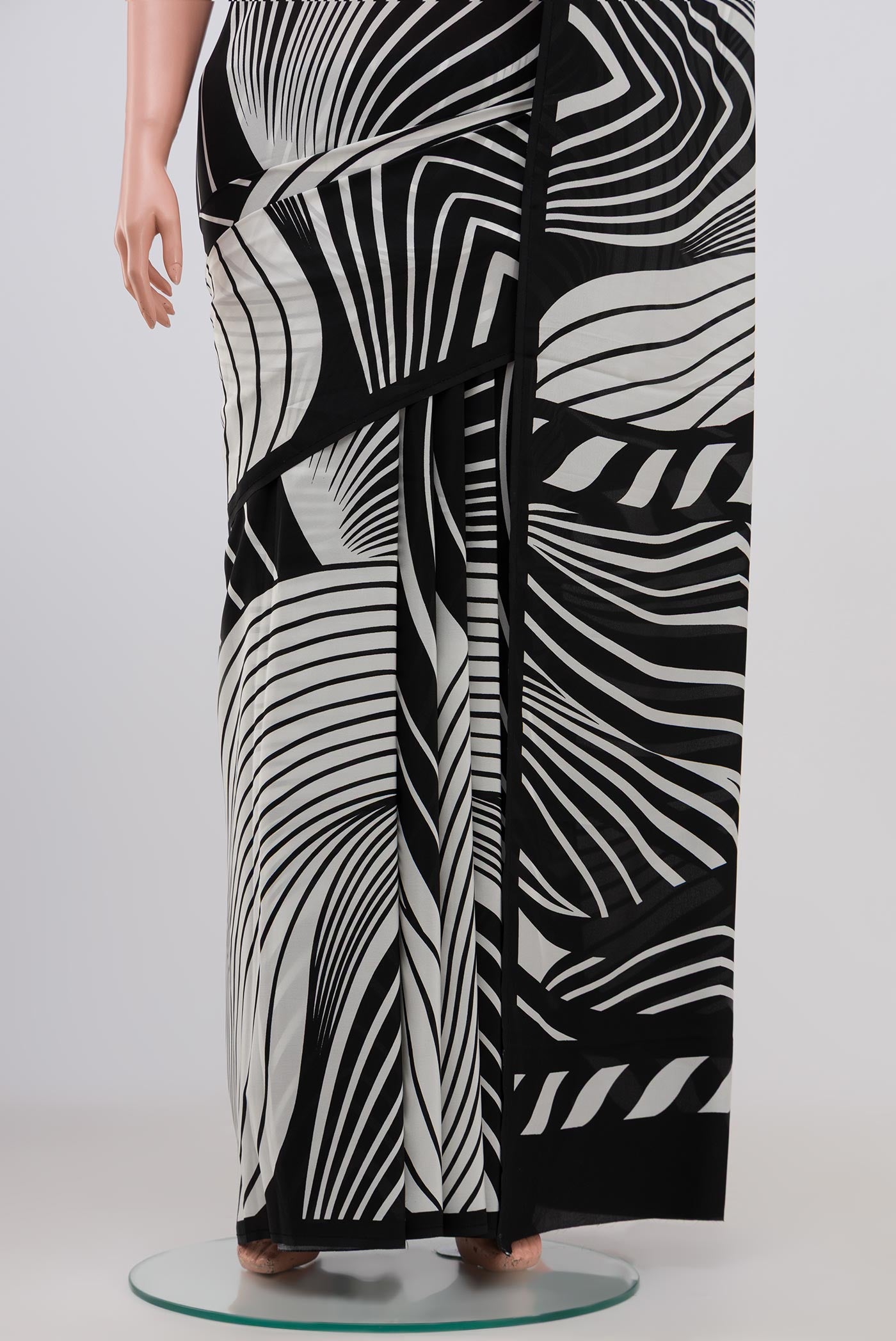 Pleats and pallu of Black Crepe Saree with Printed design on the body and Plain Border. 
