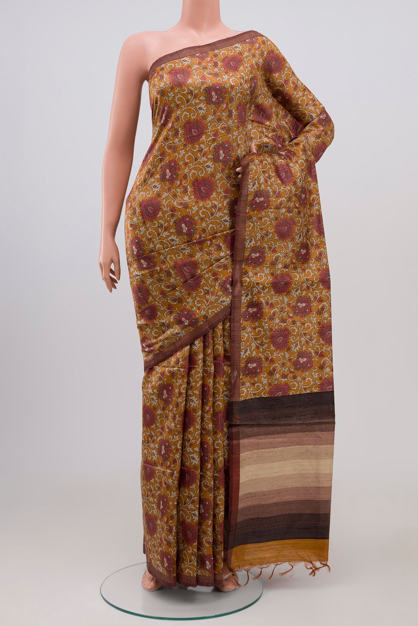 Brown Tussar Silk Saree with Printed design on the body and Thin Zari Line.  displayed on a mannequin
