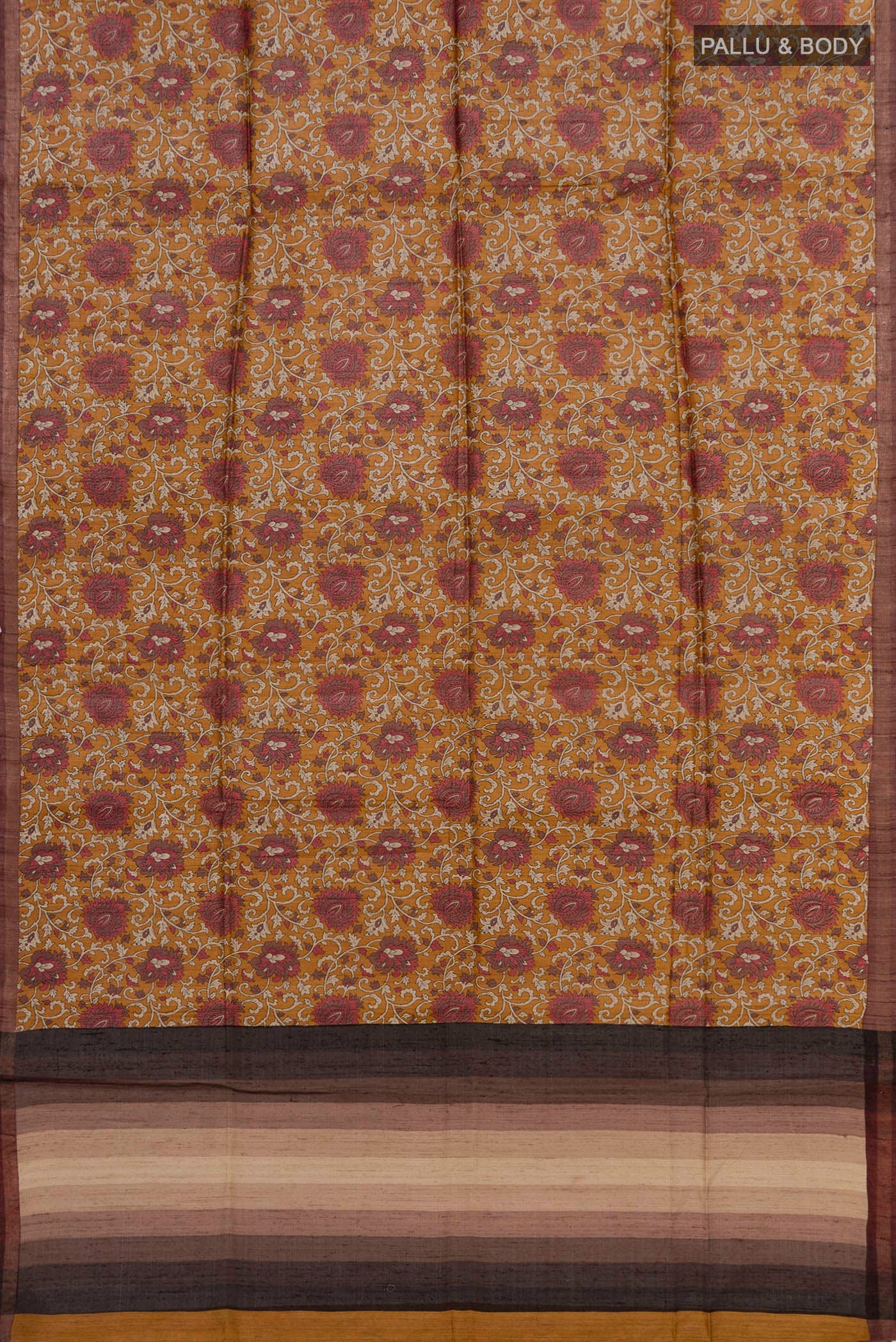 Flat view of Brown Tussar Silk Saree with Printed design on the body and Thin Zari Line. 