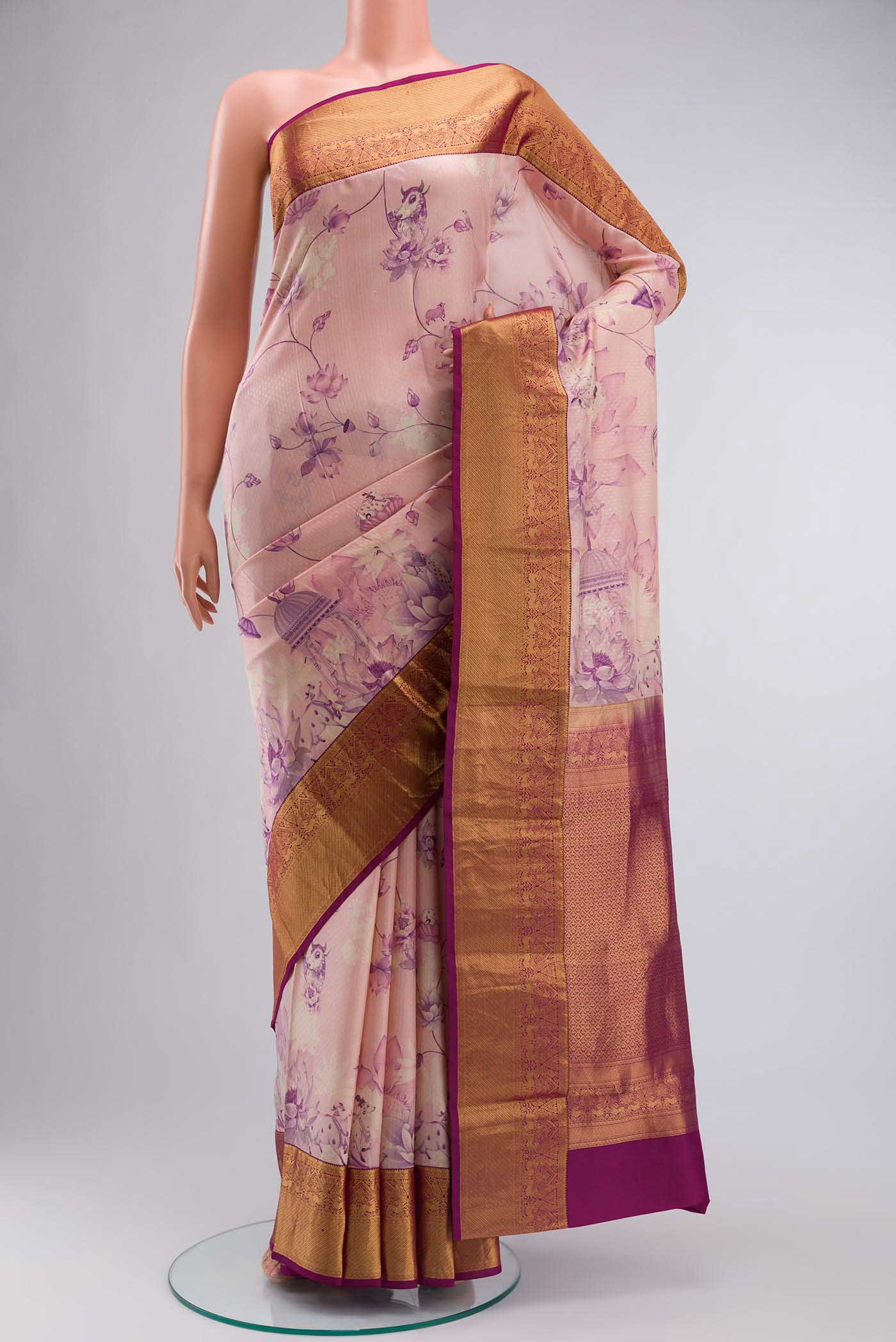 Pink Printed Silk Saree With Printed design on the body and Zari Border displayed on a mannequin