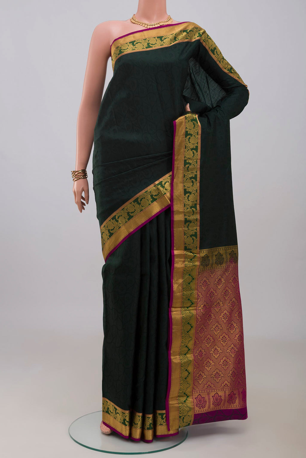 Bottle Green Kanjivaram Silk Saree with Jacquard design on the body and Zari Border.  displayed on a mannequin