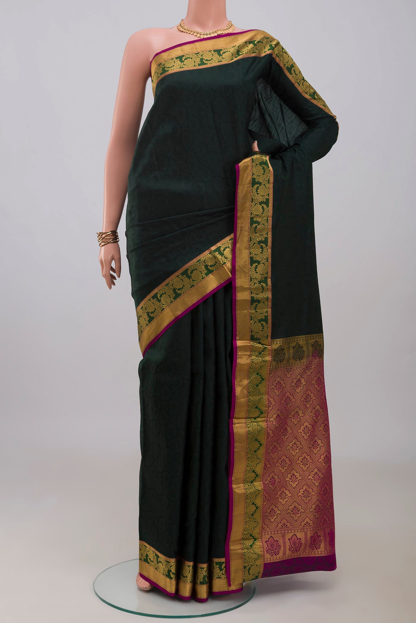 Bottle Green Kanjivaram Silk Saree with Jacquard design on the body and Zari Border.  displayed on a mannequin
