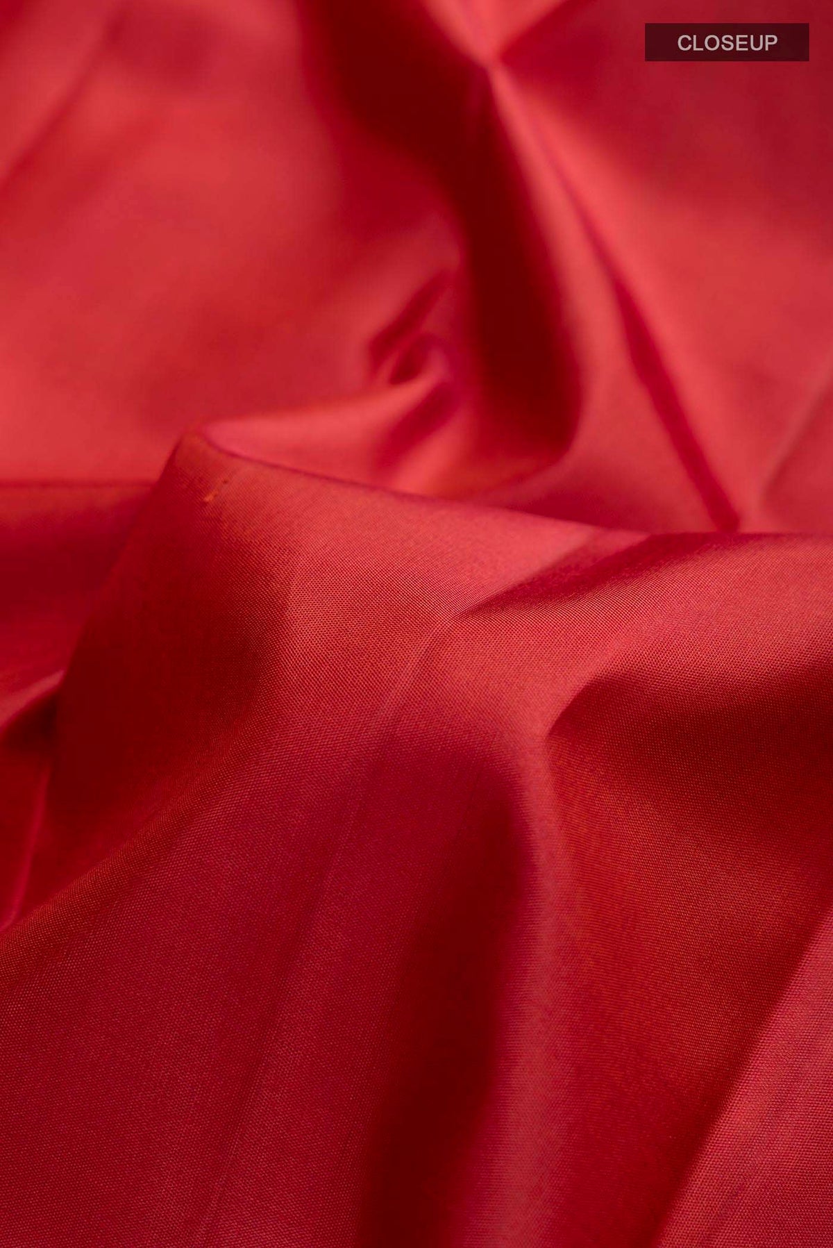 Close up of Maroon Kanchipuram Silk Saree with Zari Butta on the body and Zari Border displaying folds