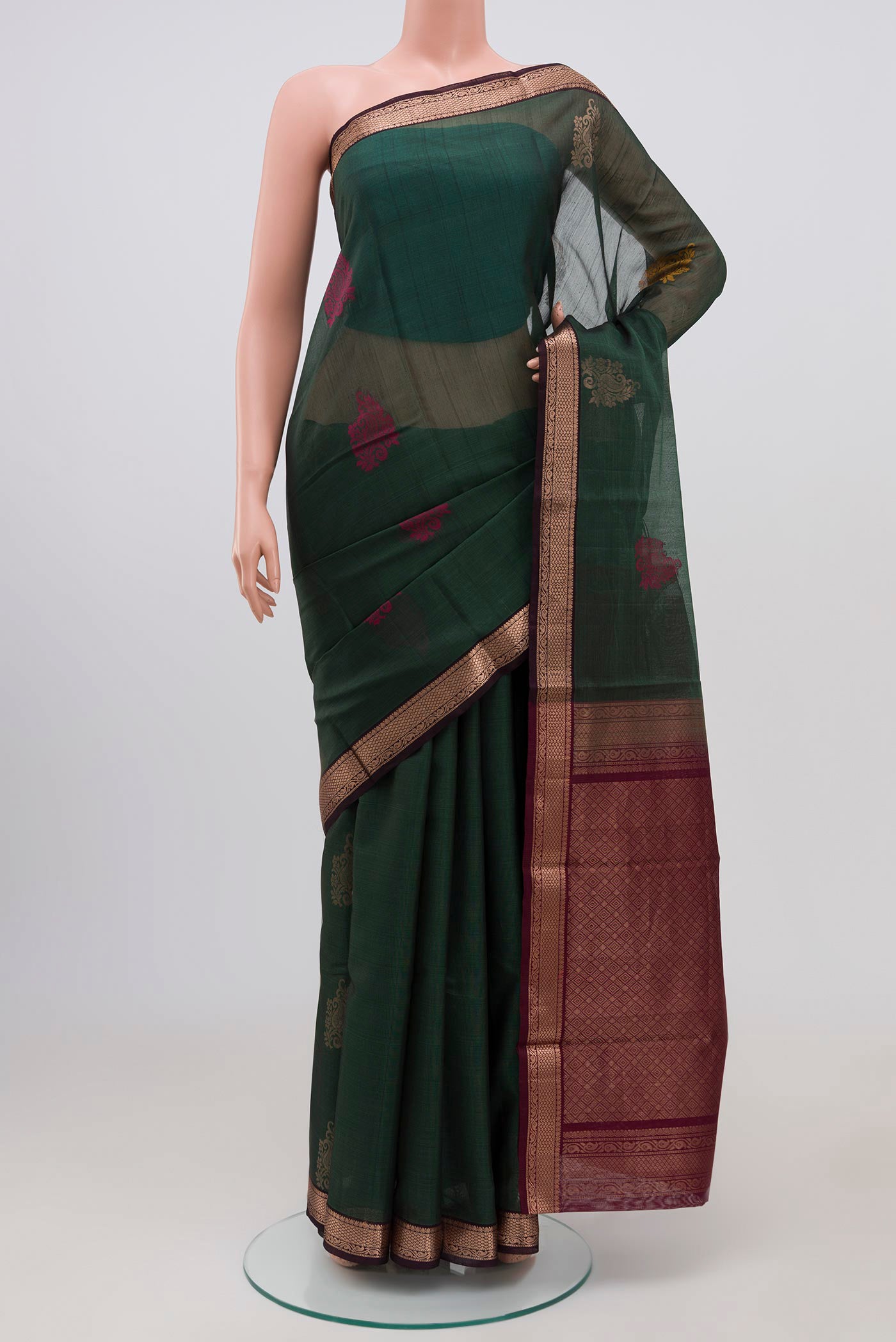 Green Coimbatore Silk Cotton Saree with Zari Butta on the body and Zari Border.  displayed on a mannequin
