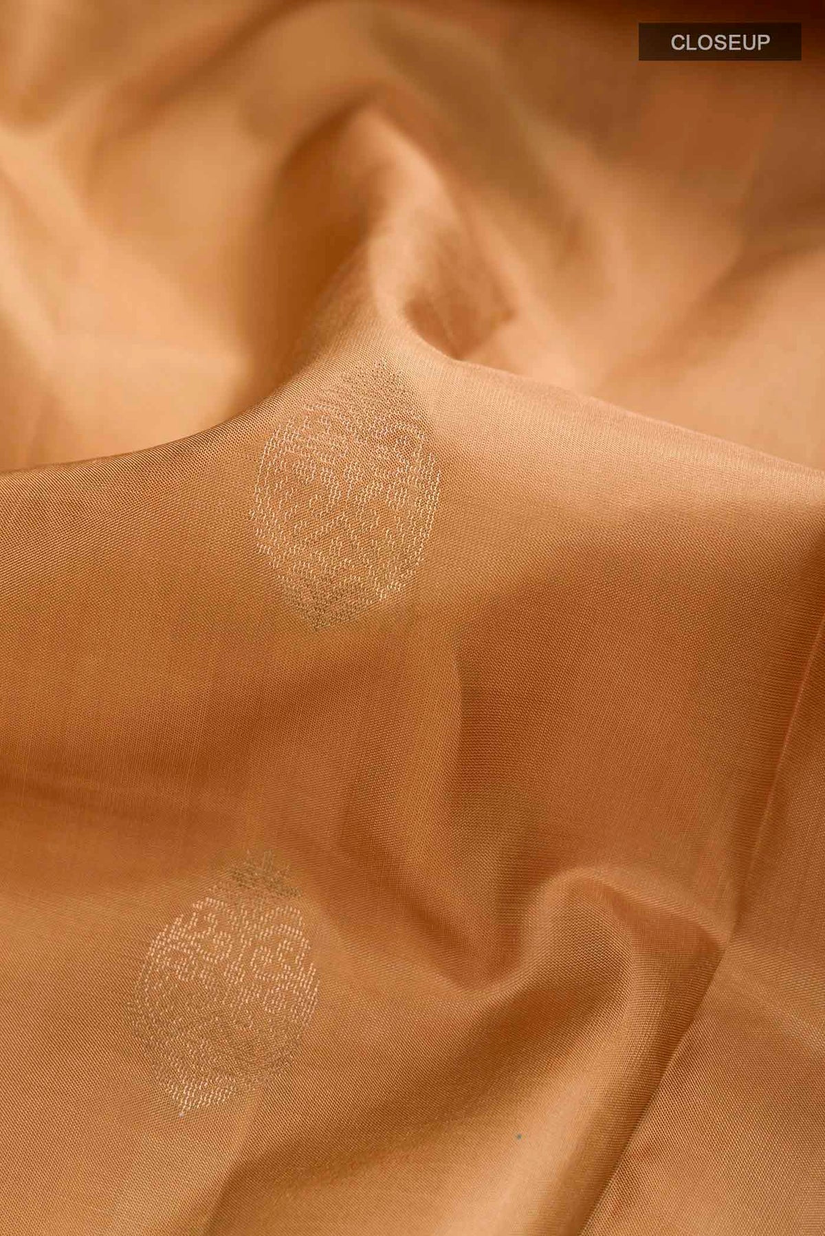 Close up of Brown Soft Silk Saree with Zari Butta on the body and Zari Border displaying folds