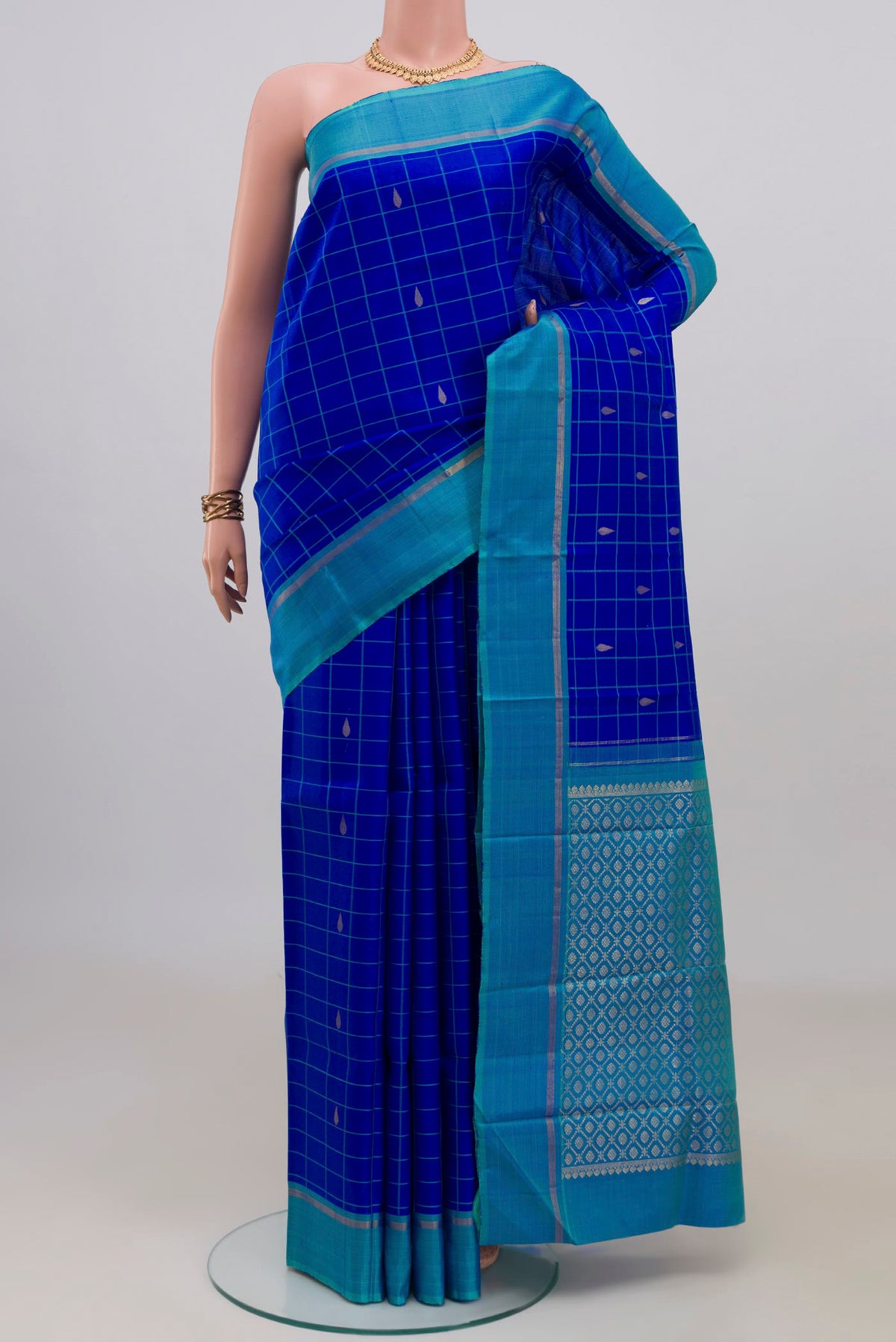 Pure Silk Royal Blue Kanjivaram Saree with Checked design on the body and Plain Border.  displayed on a mannequin
