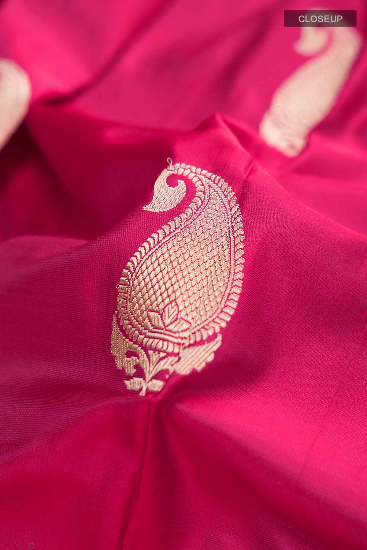 Close up of Pink Banarasi Silk Saree with Zari Butta on the body and Zari Border displaying folds