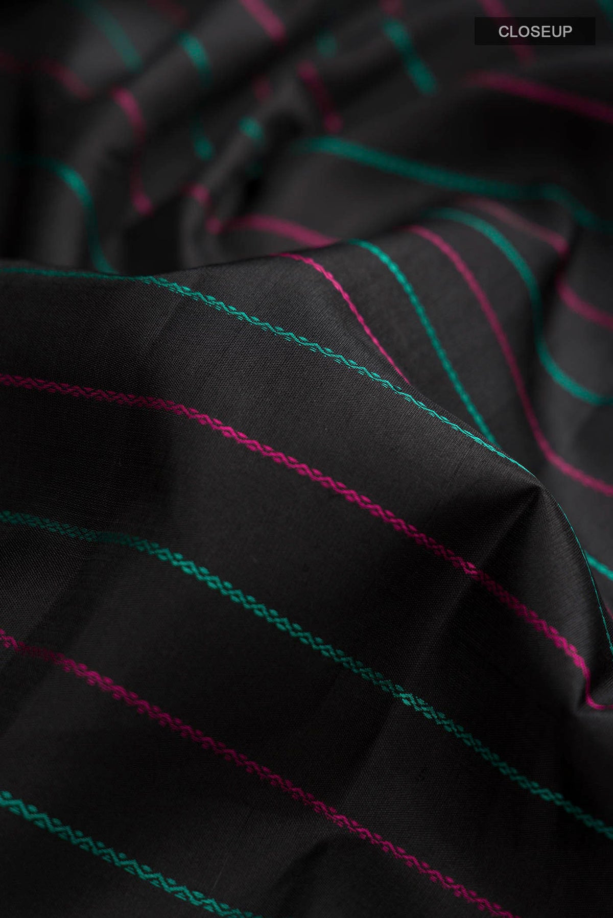 Close up of Black Kanchipuram Silk Saree with Stripes on the body and Zari Border displaying folds