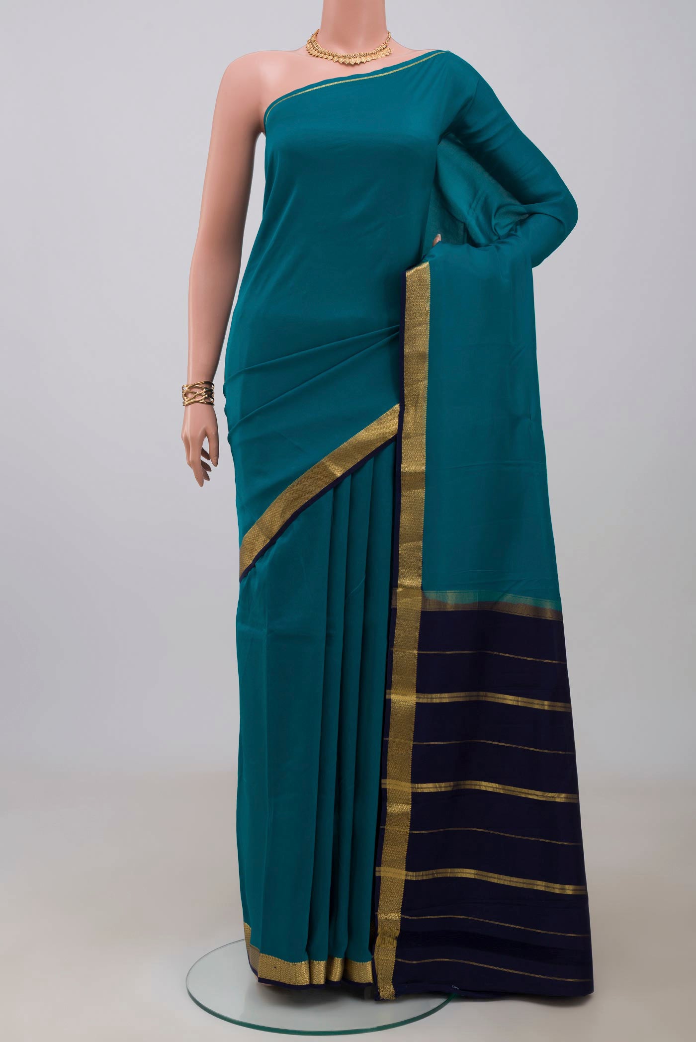 Pure Silk Pure Zari Peacock Blue Mysore Silk Saree with Plain Body and Zari Border.  displayed on a mannequin