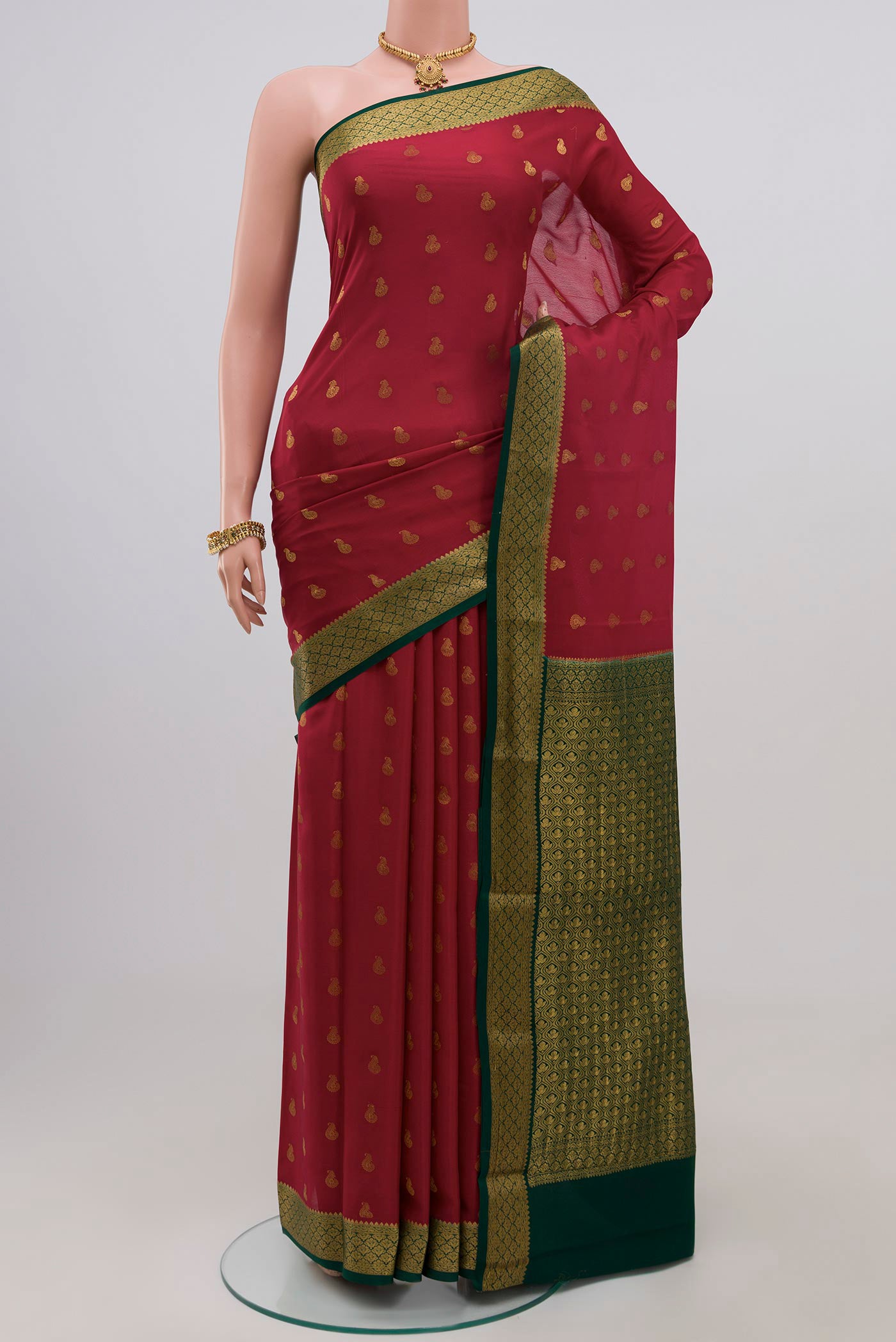 Red Crepe Saree with Zari Butta on the body and Zari Border.  displayed on a mannequin