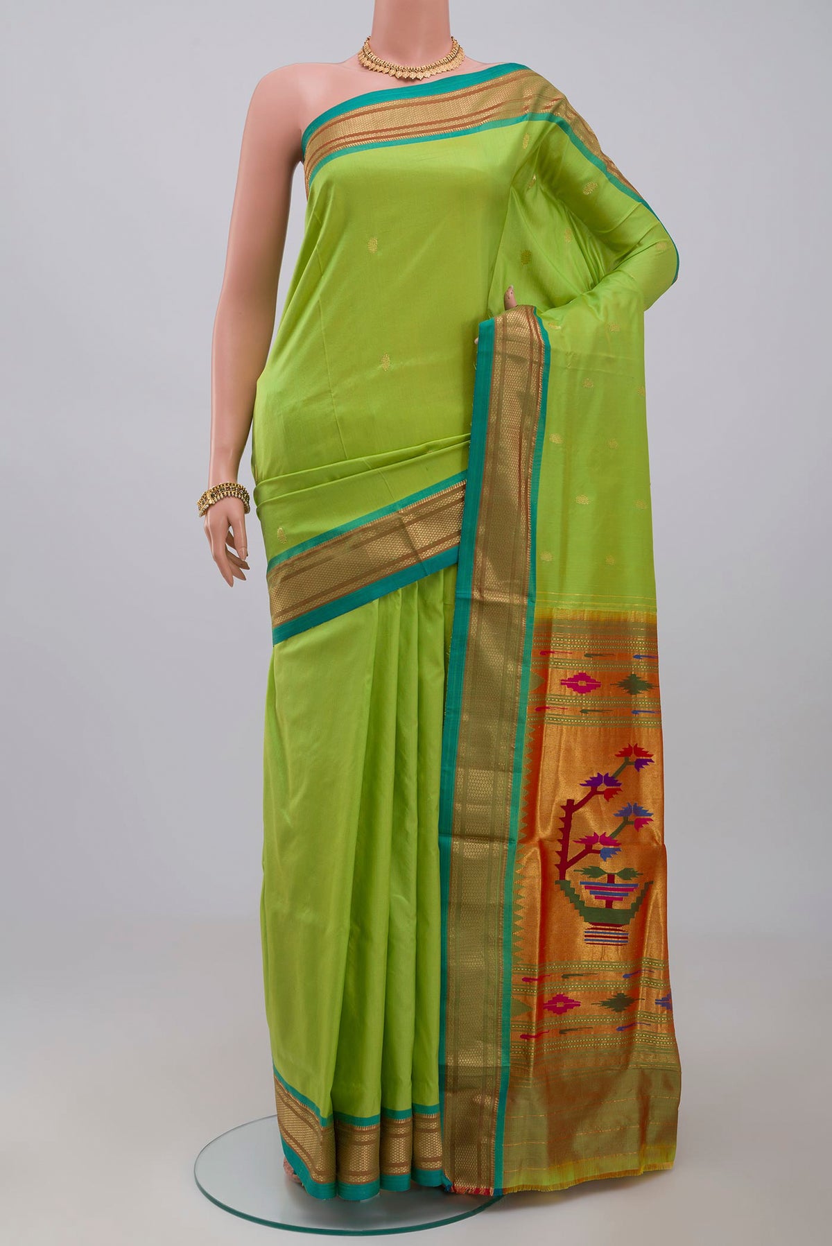 Green Paithani Silk Saree with Zari Butta on the body and Zari Border.  displayed on a mannequin