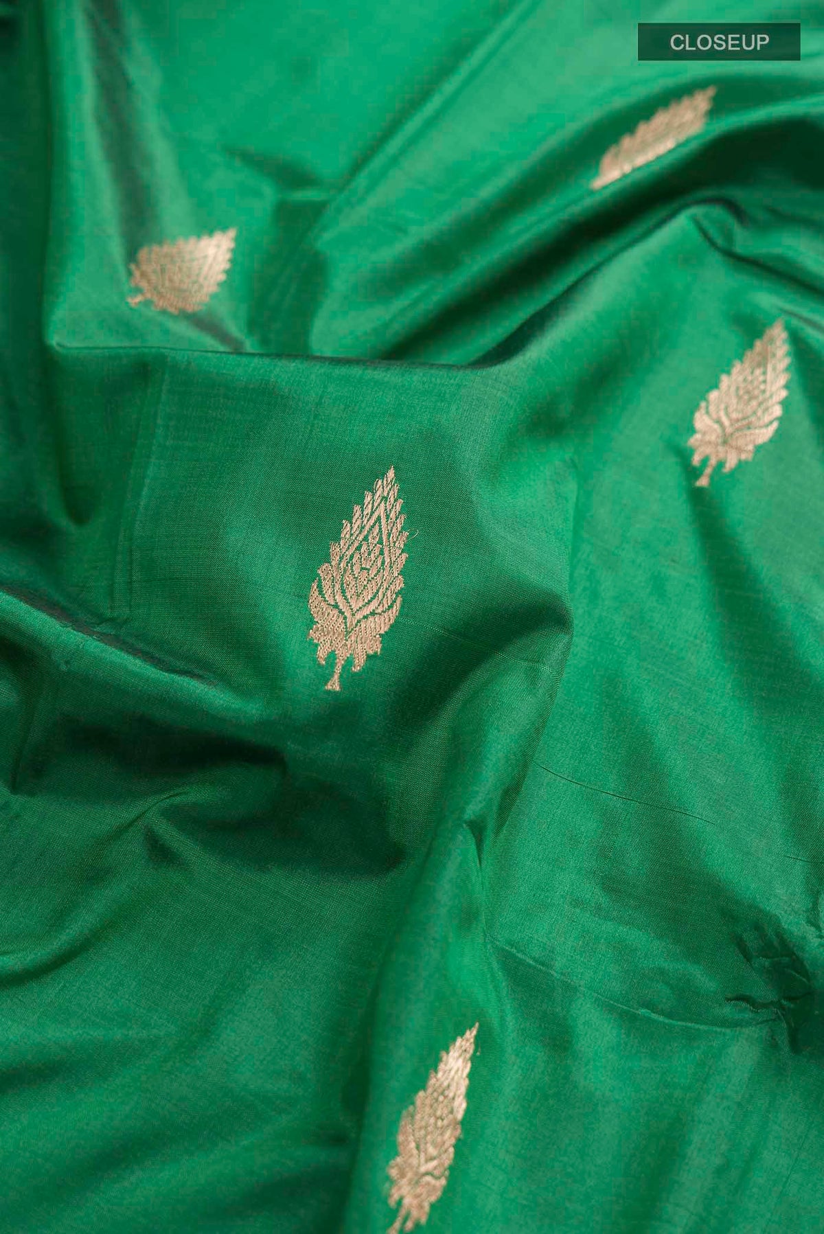 Close up of Green Banarasi Katan Silk Saree with Zari Butta on the body and Zari Border displaying folds