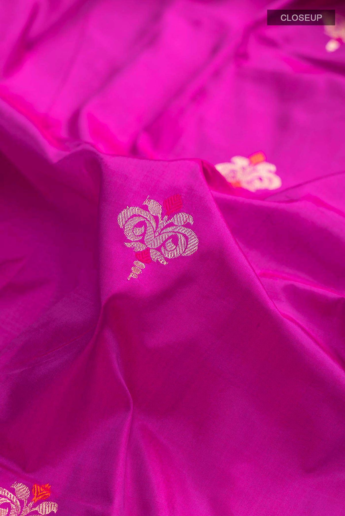 Close up of Light Magenta Banarasi Katan Silk Saree with Zari Butta on the body and Zari Border displaying folds