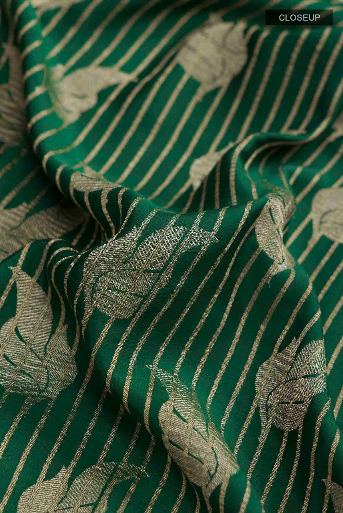 Close up of Green Mysore Crepe Saree with Zari Butta on the body and Zari Border displaying folds
