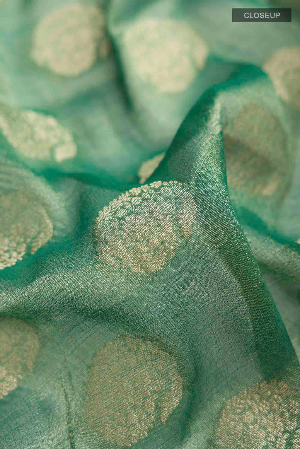 Close up of Green Banarasi Georgette Saree with Zari Butta on the body and Zari Border displaying folds