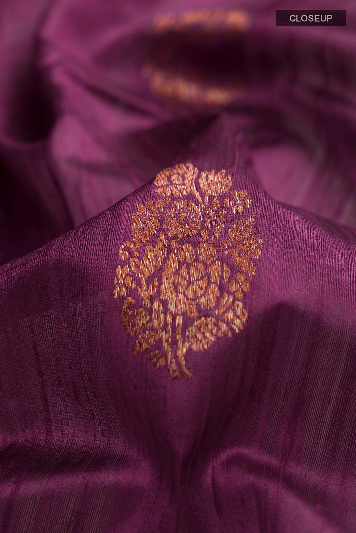 Close up of Burgundy Banarasi Tussar Silk Saree with Zari Butta on the body and Zari Border displaying folds