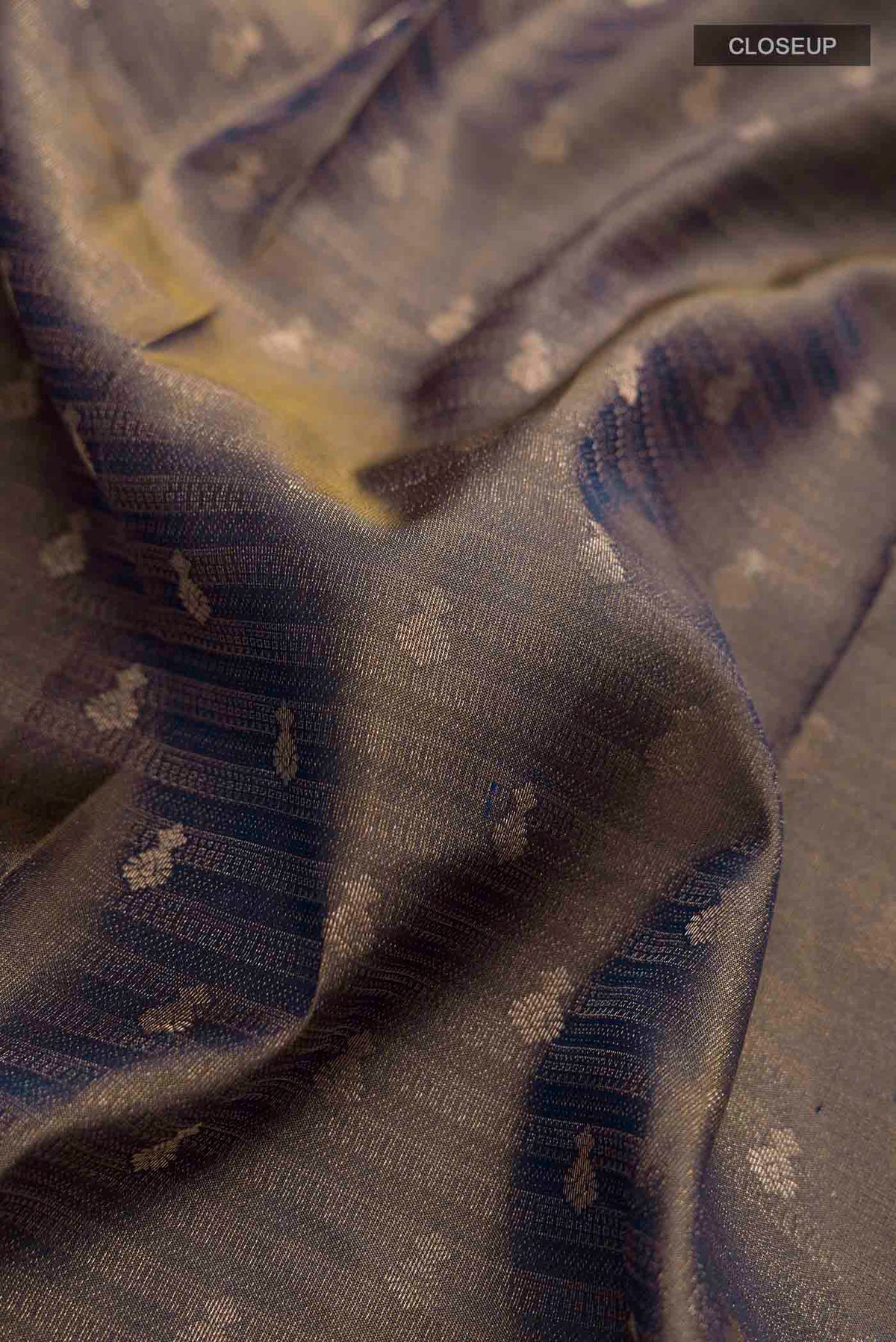 Close up of Grey Kanchipuram Silk Saree with Zari Butta on the body and Zari Border displaying folds