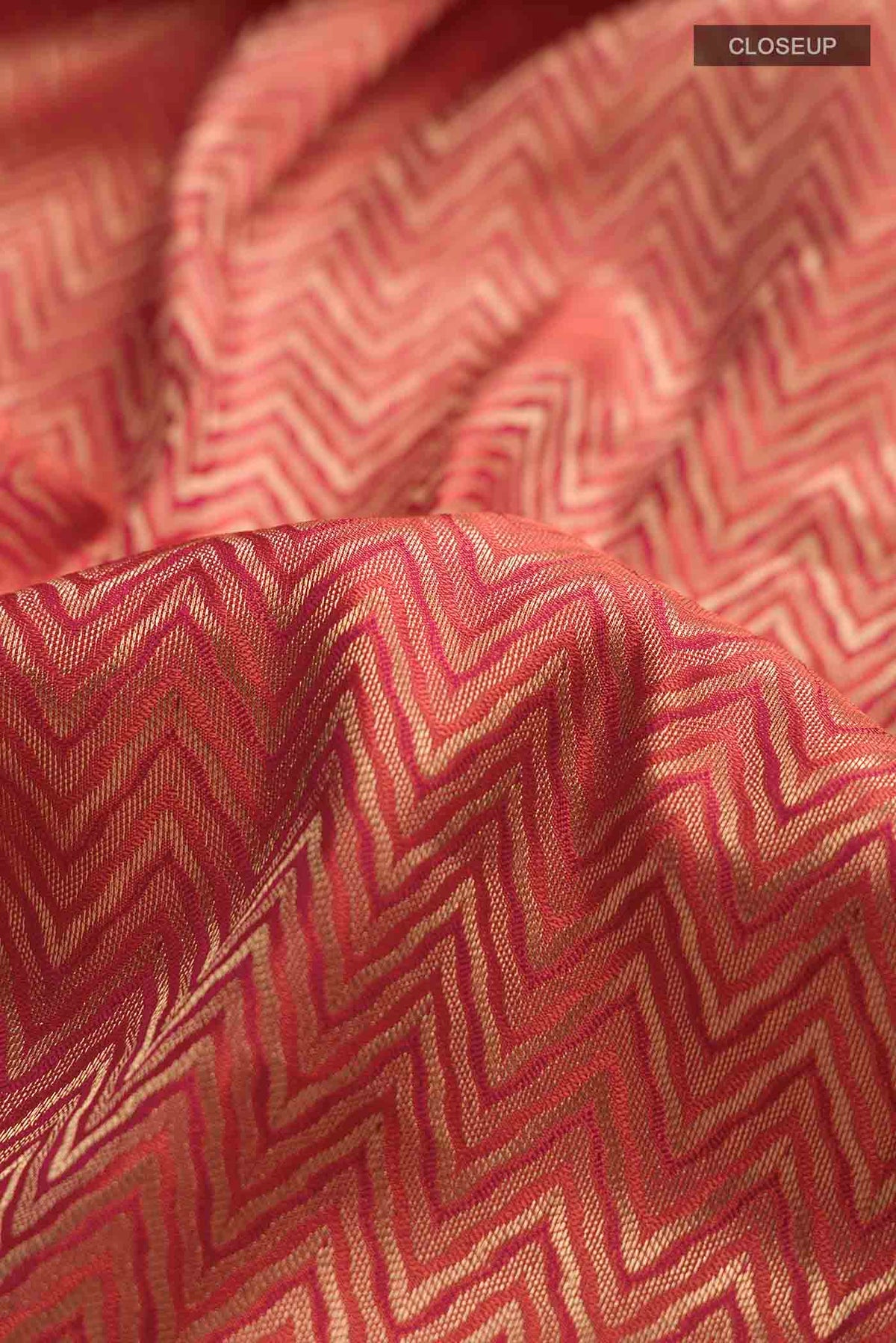 Close up of Rust Kanchipuram Silk Saree with Zari Brocade on the body and Zari Border displaying folds