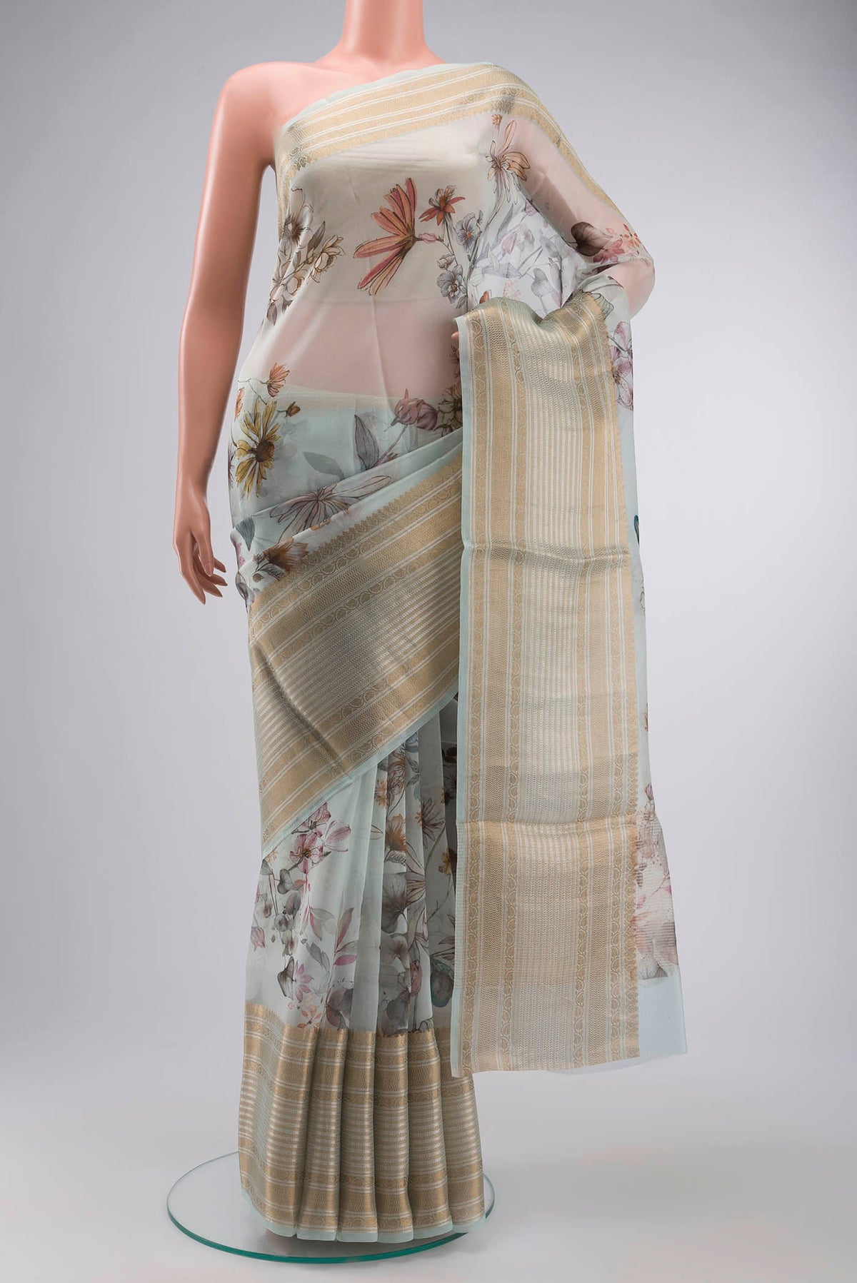 Light Blue Organza Silk Saree with Printed design on the body and Zari Border displayed on a mannequin