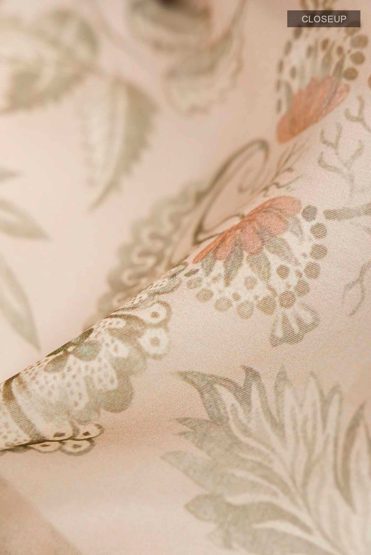Close up of Beige Organza Silk Saree with Floral Print on the body and Zari Border displaying folds