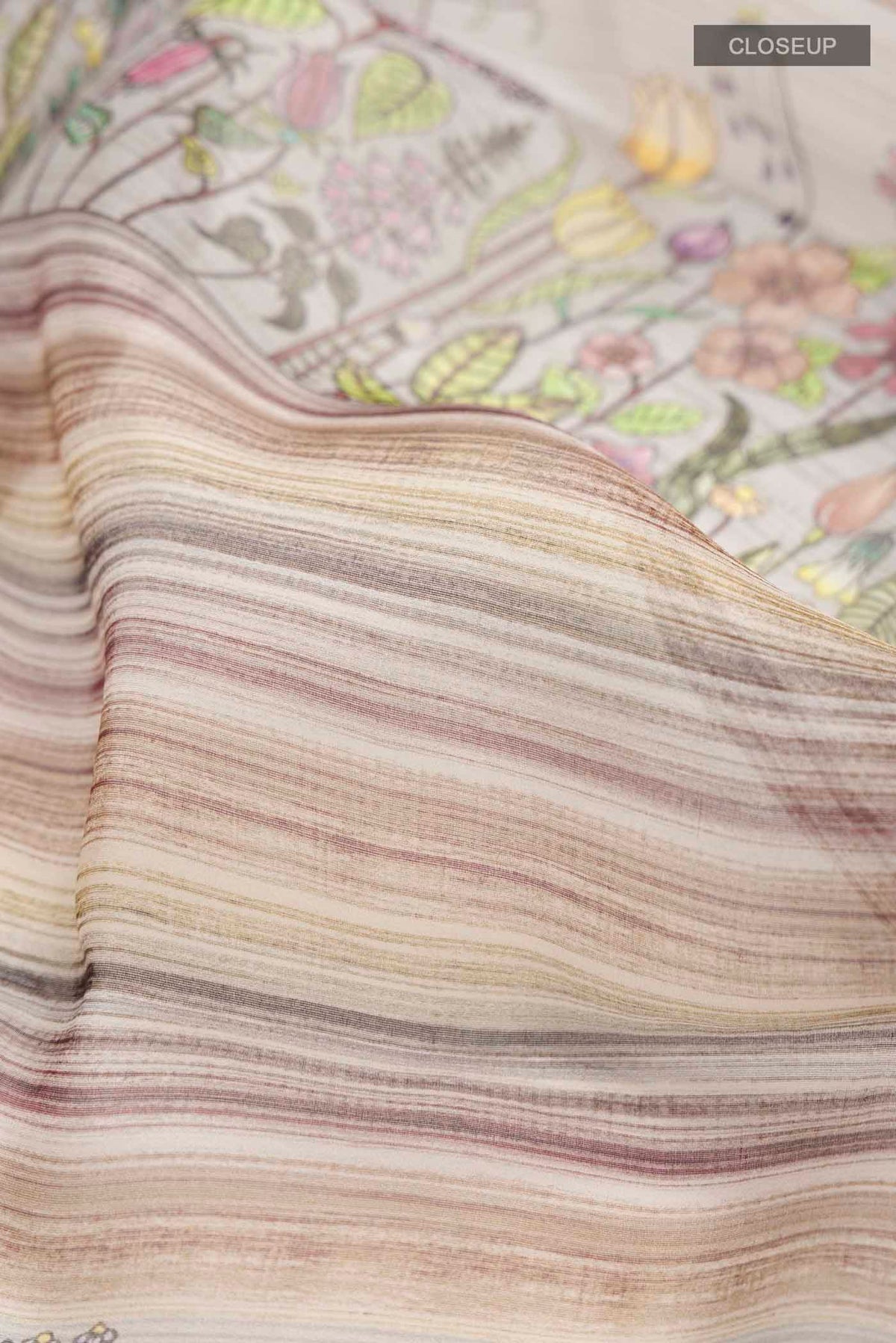 Close up of Grey Organza Silk Saree with Printed design on the body and Zari Border displaying folds