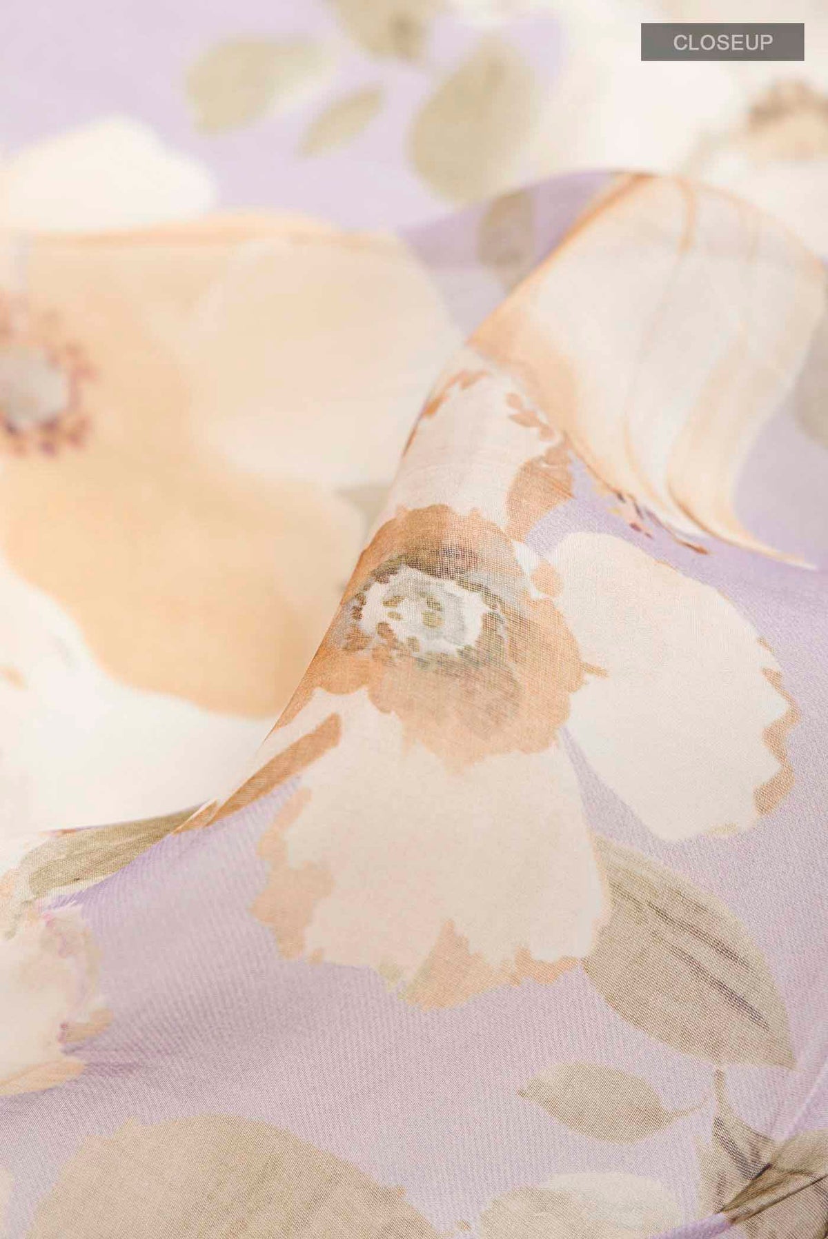 Close up of Lavender Organza Silk Saree with Printed design on the body and Zari Border displaying folds