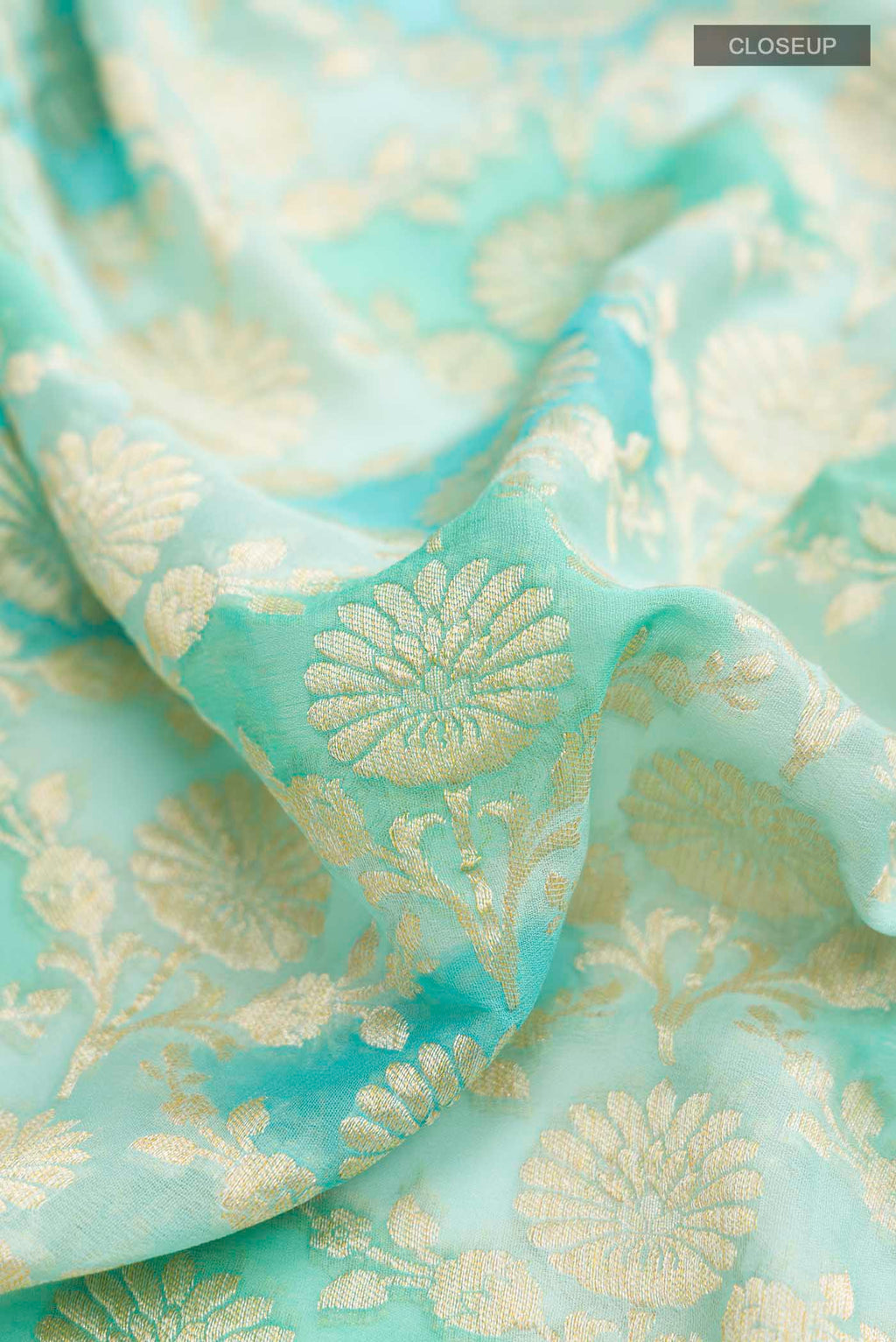Close up of Light Blue Banarasi Georgette Saree with Zari Butta on the body and Zari Border displaying folds