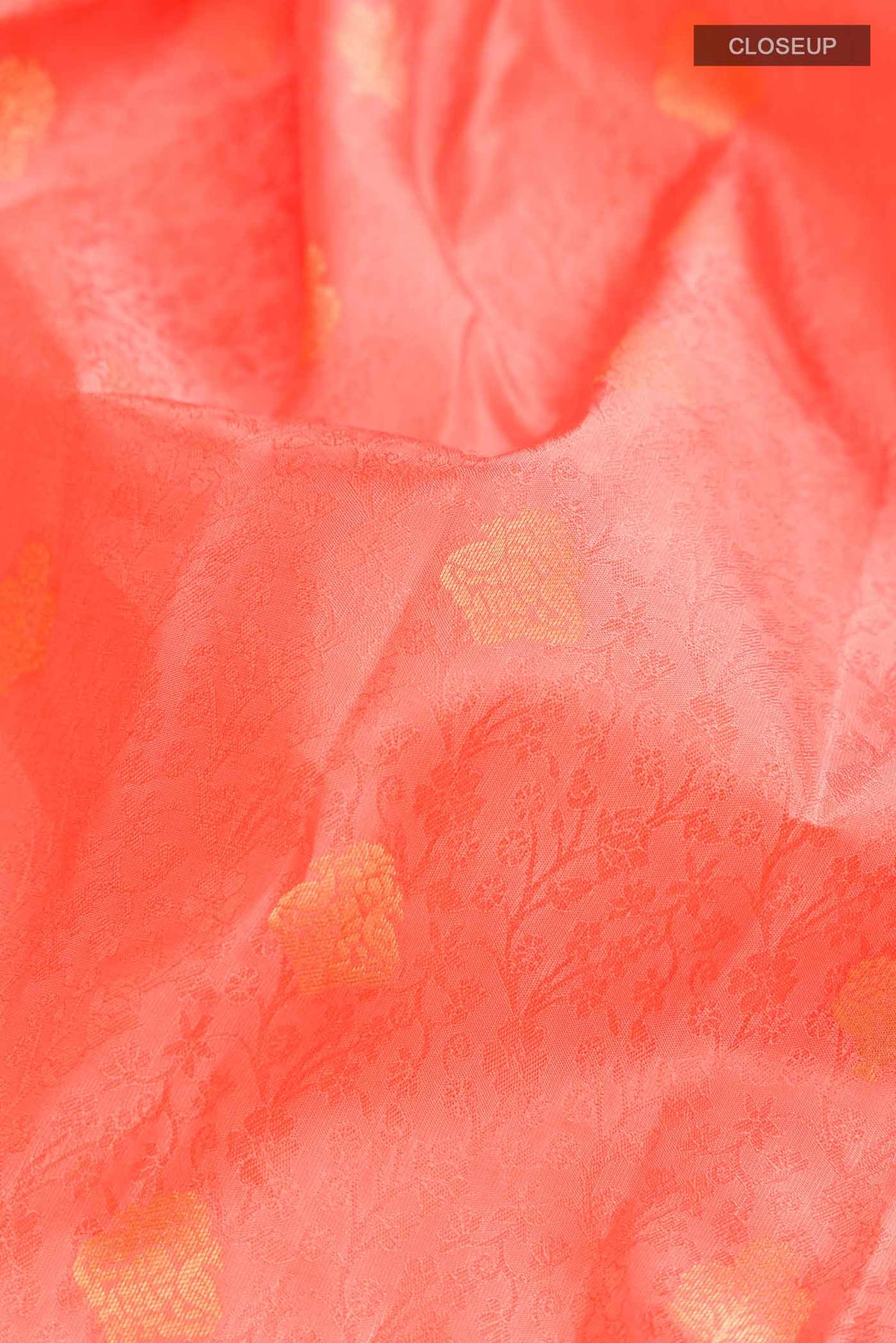 Close up of Coral Kanchipuram Silk Saree with Jacquard With Zari Butta on the body and Zari Border displaying folds