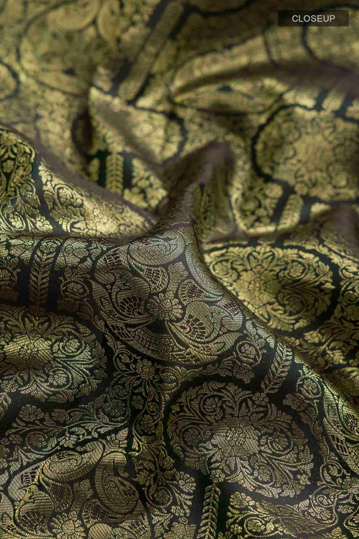 Close up of Bottle Green Kanchipuram Silk Saree with Zari Brocade on the body and Zari Border displaying folds