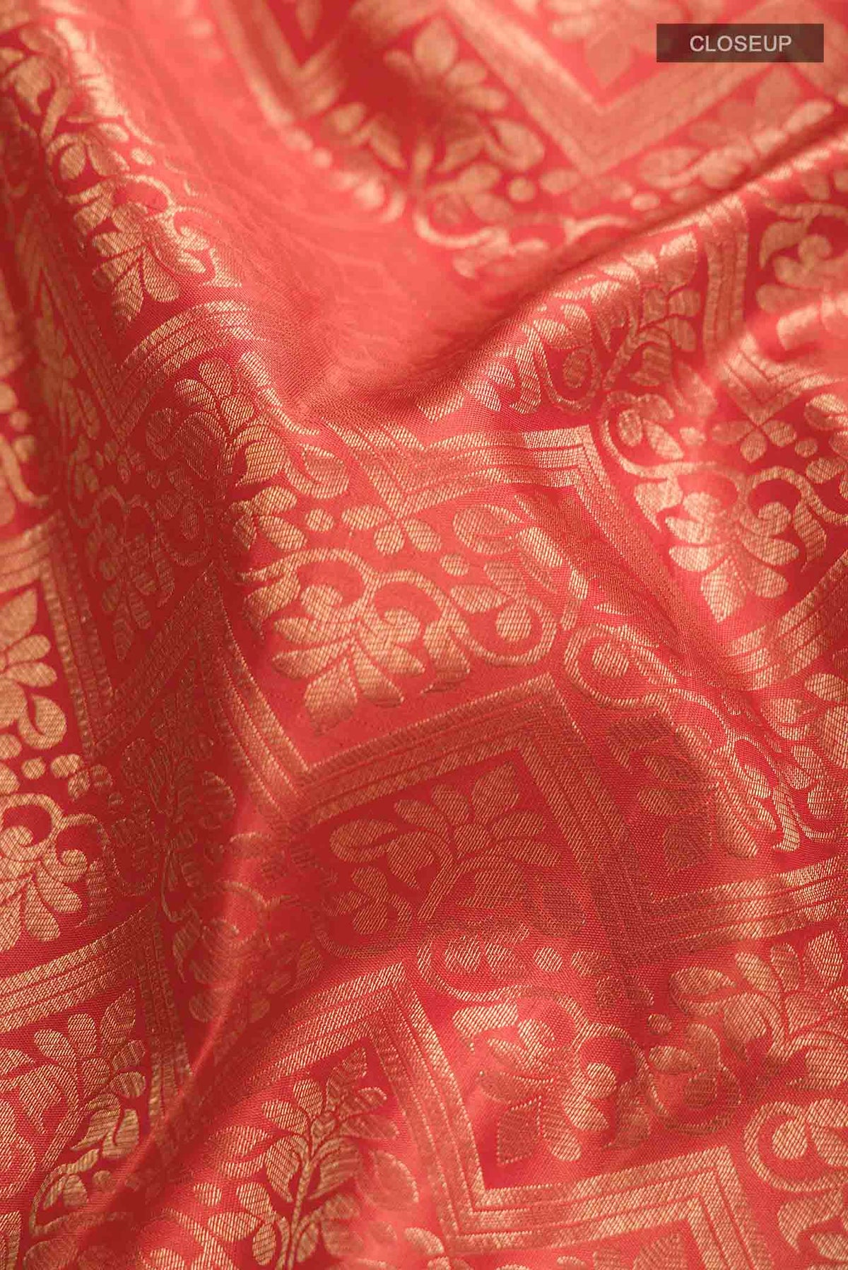 Close up of Orange Kanchipuram Silk Saree with Zari Brocade on the body and Zari Border displaying folds