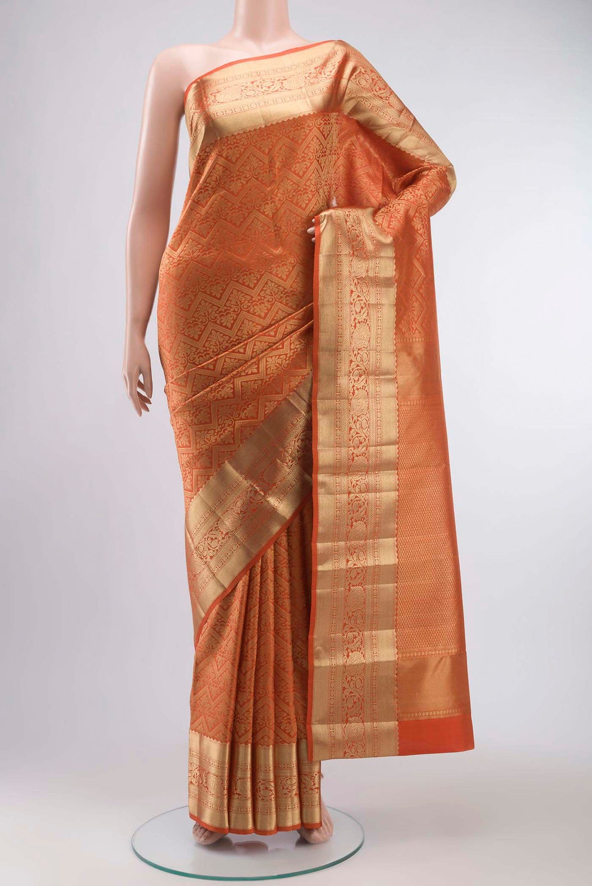 Orange Kanchipuram Silk Saree with Zari Brocade on the body and Zari Border displayed on a mannequin