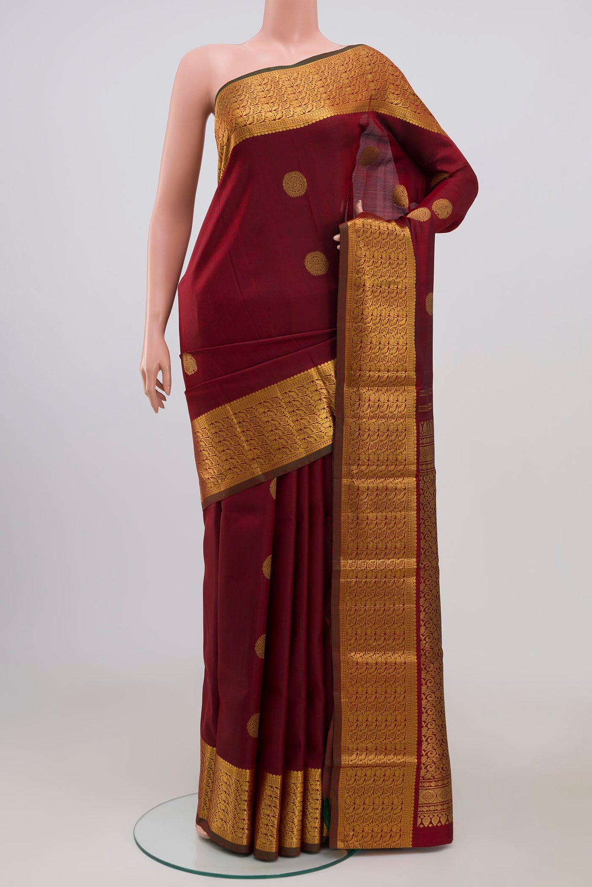 Pure Silk Pure Zari Maroon Kanchipuram Saree with Zari Butta on the body and Zari Border.  displayed on a mannequin